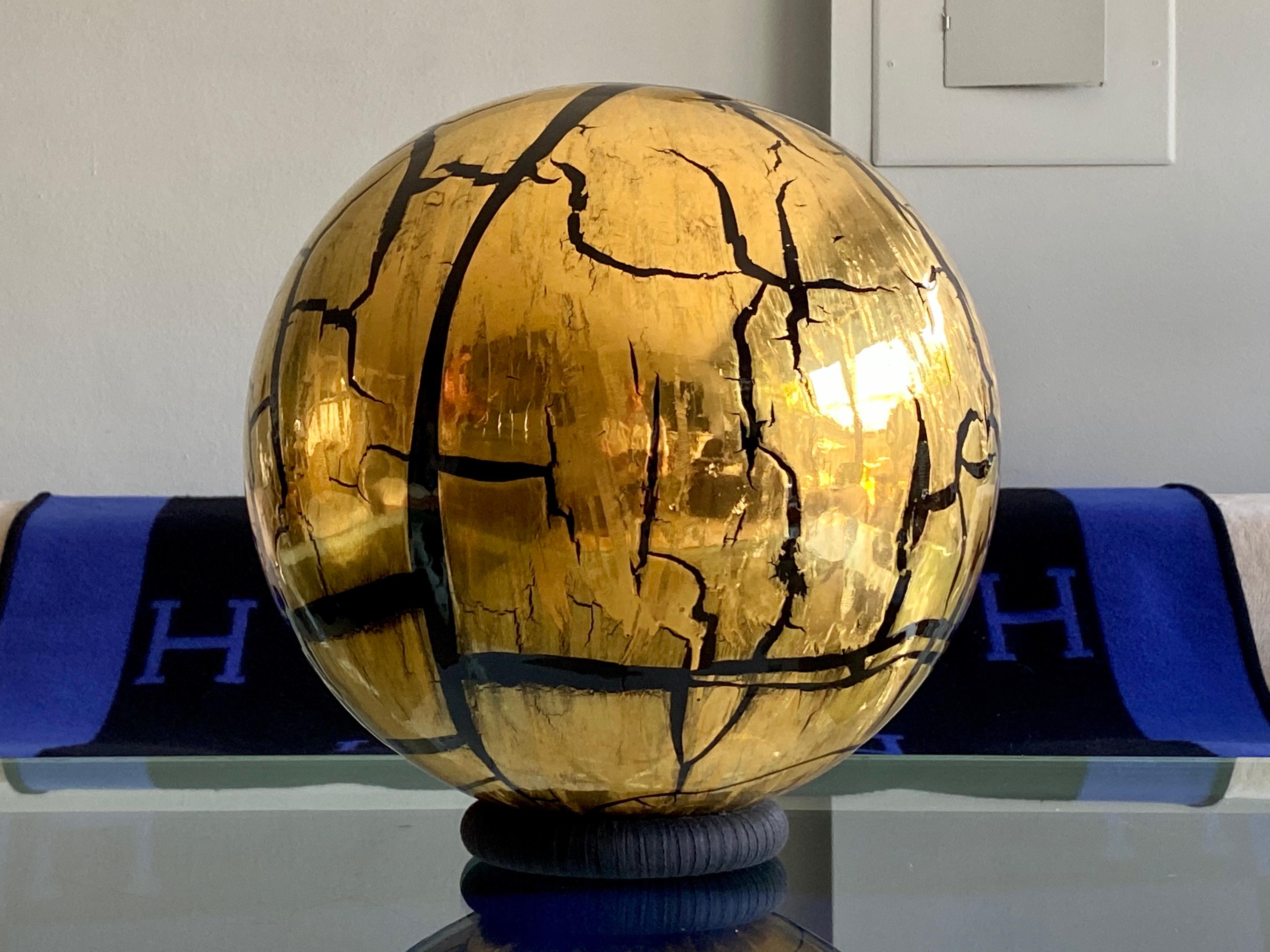 Larry Lubow Sphere sculpture with circle shaped pedestal.
The fractures, the random abstractions of lines in crackle type finish over the gold-plated ceramic sphere sculpture is by the artist Larry Lubow and signed. Dated 96.
