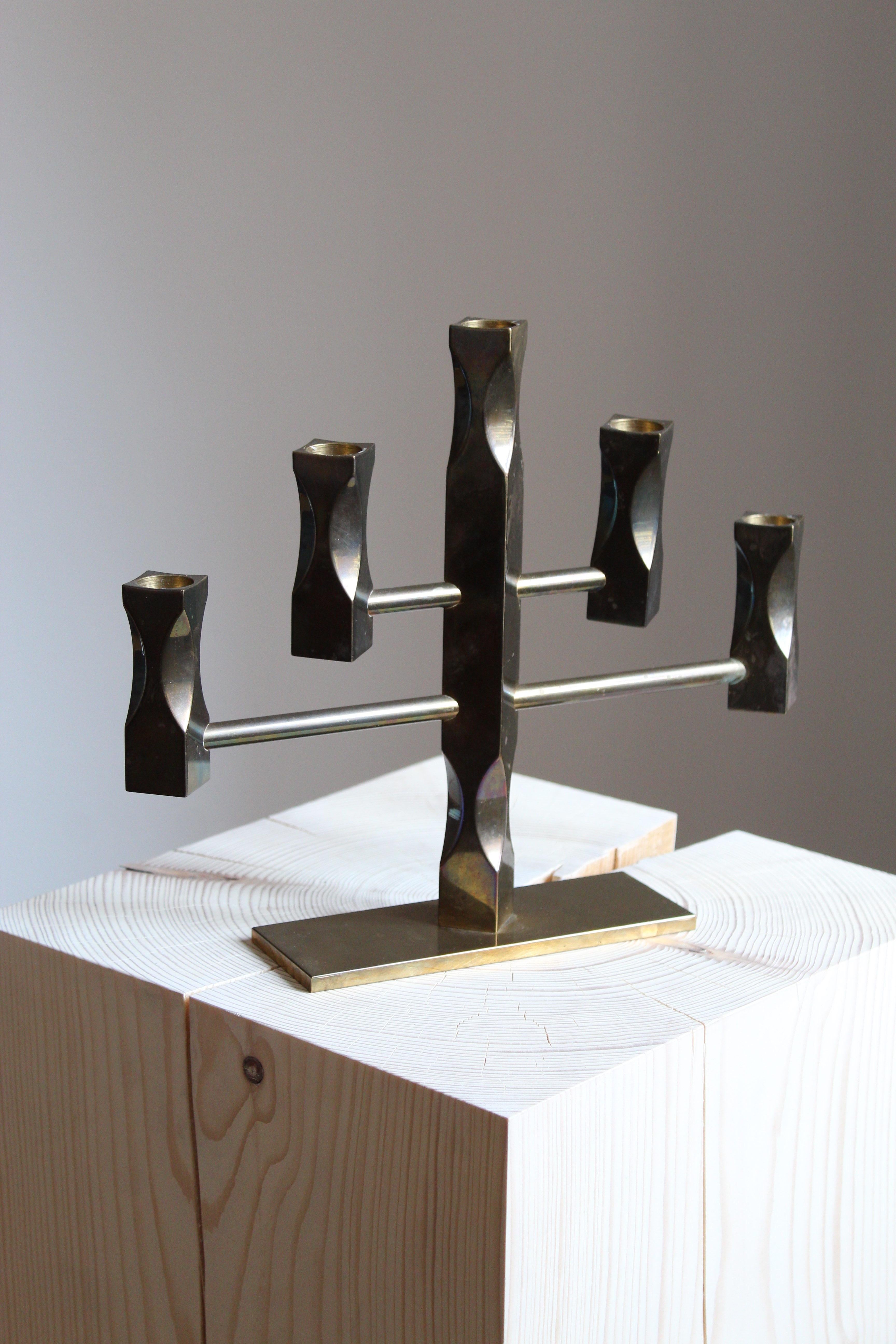 A candelabra. In brass, very heavy alloy. Designed by Lars Åkesson. This example signed and dated 1984.
   
  