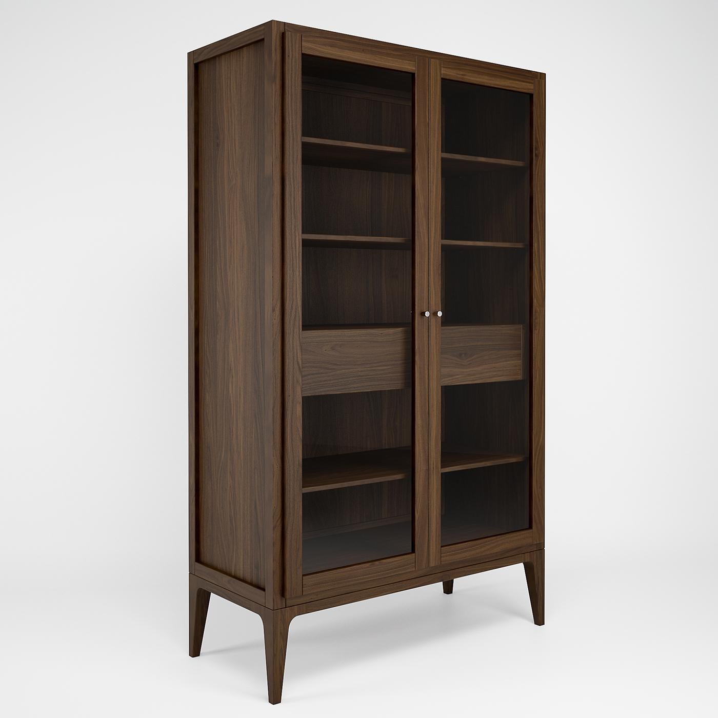 Handcrafted of solid American walnut with meticulous attention to detail, this remarkable display cabinet is Italian finesse epitomized. Showcasing a grand, linear silhouette, the deliberate lack of ornate detailing lets the warm and rich wood tones