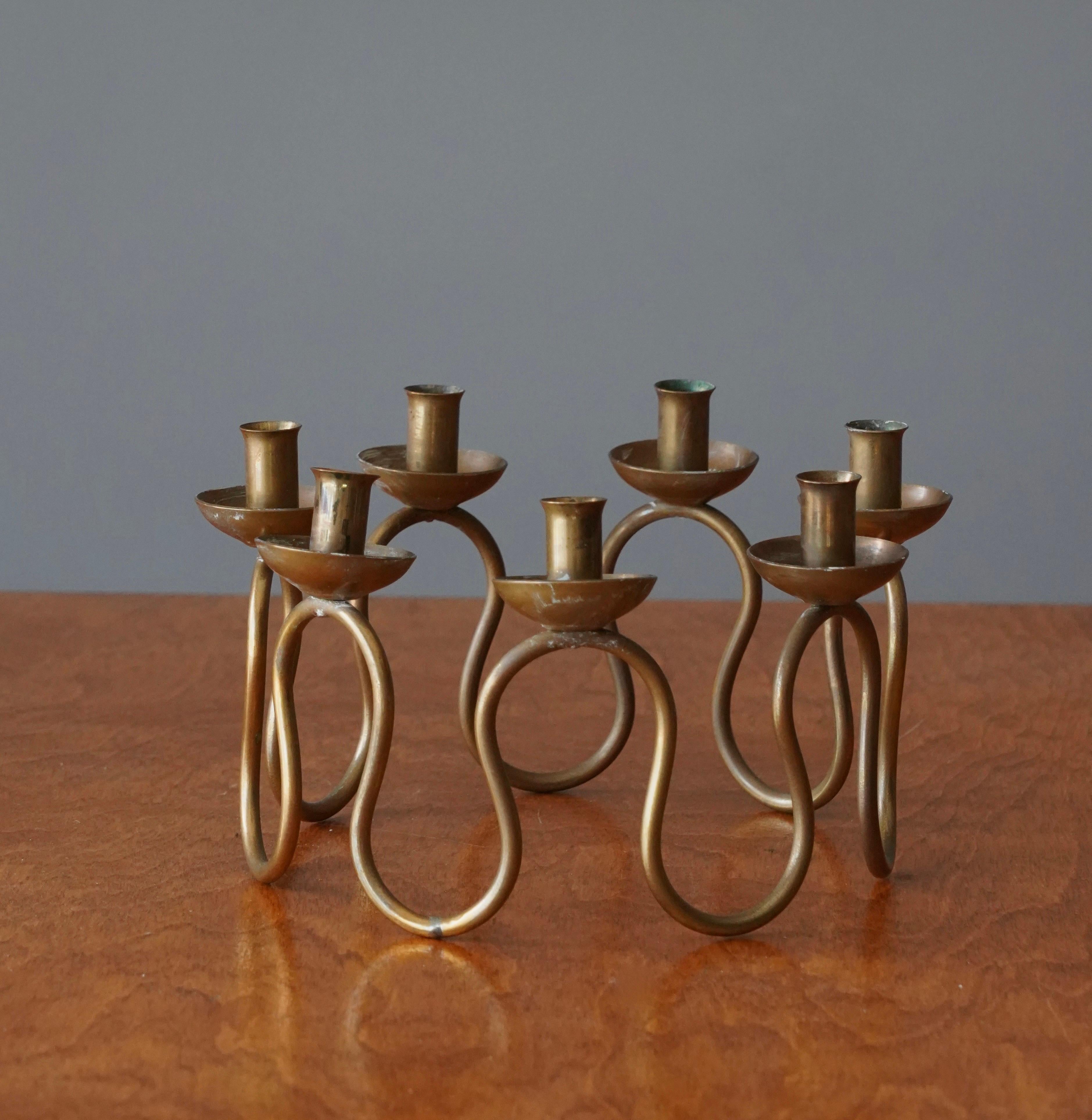 An organic candelabra, designed by Lars Holmström for Svenskt Tenn, Sweden, 1950s. In brass. For small candles. Accepts 0.5 inch diameter candles

Other designers of the period include Piet Hein, Paavo Tynell, Josef Frank, and Jean Royere.

