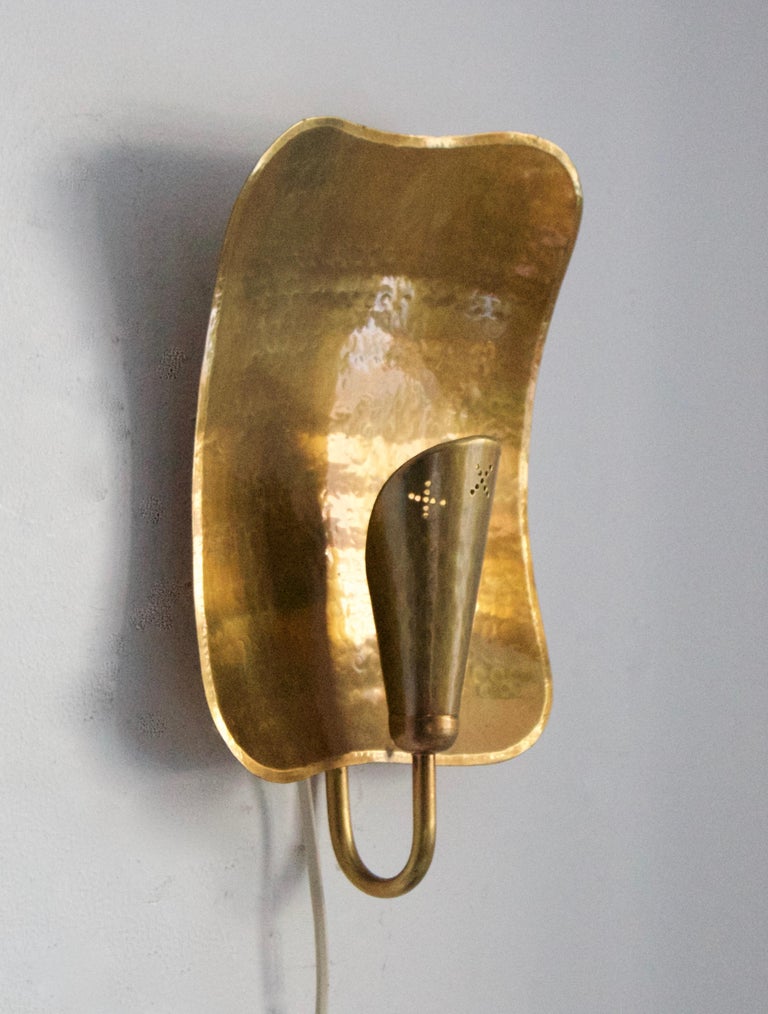 A pair of wall lights / sconces. Designed and produced by Lars Holmström, Studio, Arvika, Sweden, 1930s.

In hammered brass with perforated detailing. Stamped.

Other designers of the period include Carl-Axel Acking, Paavo Tynell, Jean Royère,