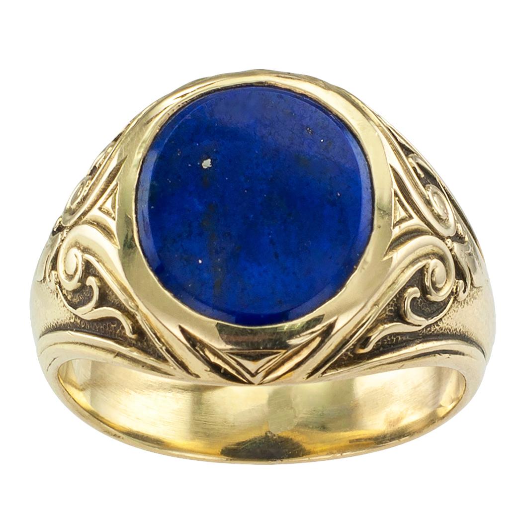 Larter & Sons Art Nouveau lapis lazuli and gold gentleman’s ring circa 1905. Centering a bezel-set, buff-top lapis lazuli displaying beautiful blue color with small pyrite markings, between shoulders decorated with classical scrolling motifs, in