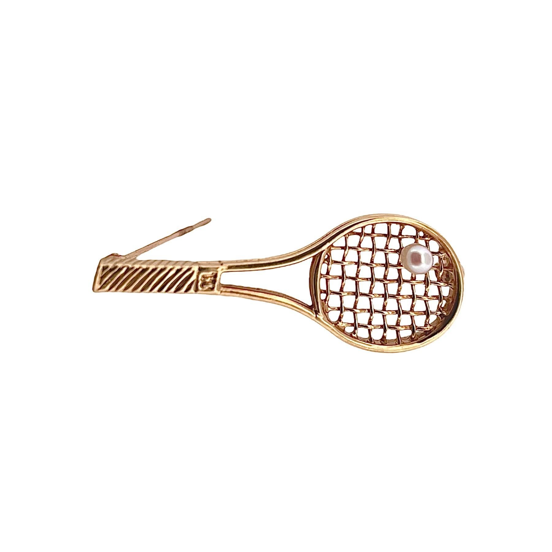 Larter & Sons Tennis Racket Brooch, a stunning piece that blends sporty elegance with timeless charm. Crafted in radiant 14K yellow gold.
At the heart of the brooch, a dainty 3.5mm pearl serves as the tennis ball, adding a touch of sophistication to