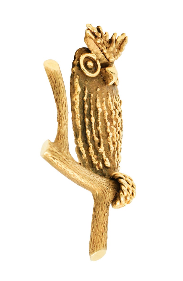 Brooch is designed as a stylized texturous owl perched on a branch

With twisted rope feet, dripped gold feathers, and realistic wood grained branch

Completed by a pin stem with locking closure

Stamped 14K for 14 karat gold

Maker's mark for