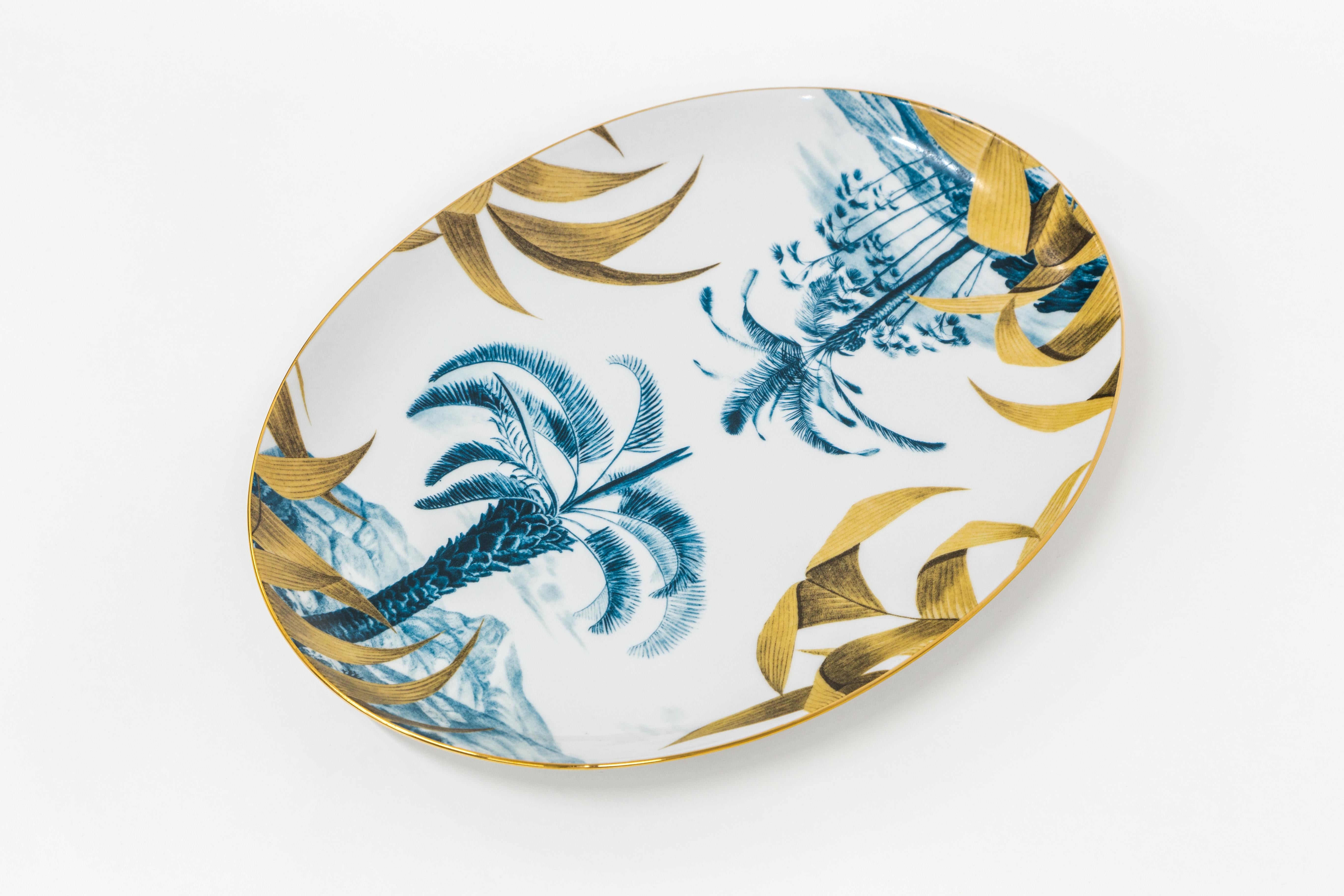 This 28x38cm oval tray is part of Las Palmas collection by Grand Tour by Vito Nesta. The classic and versatile shape is a must-have inside any home to embellish a table or beautify a wall. This tray features two blue tropical landscapes whose main