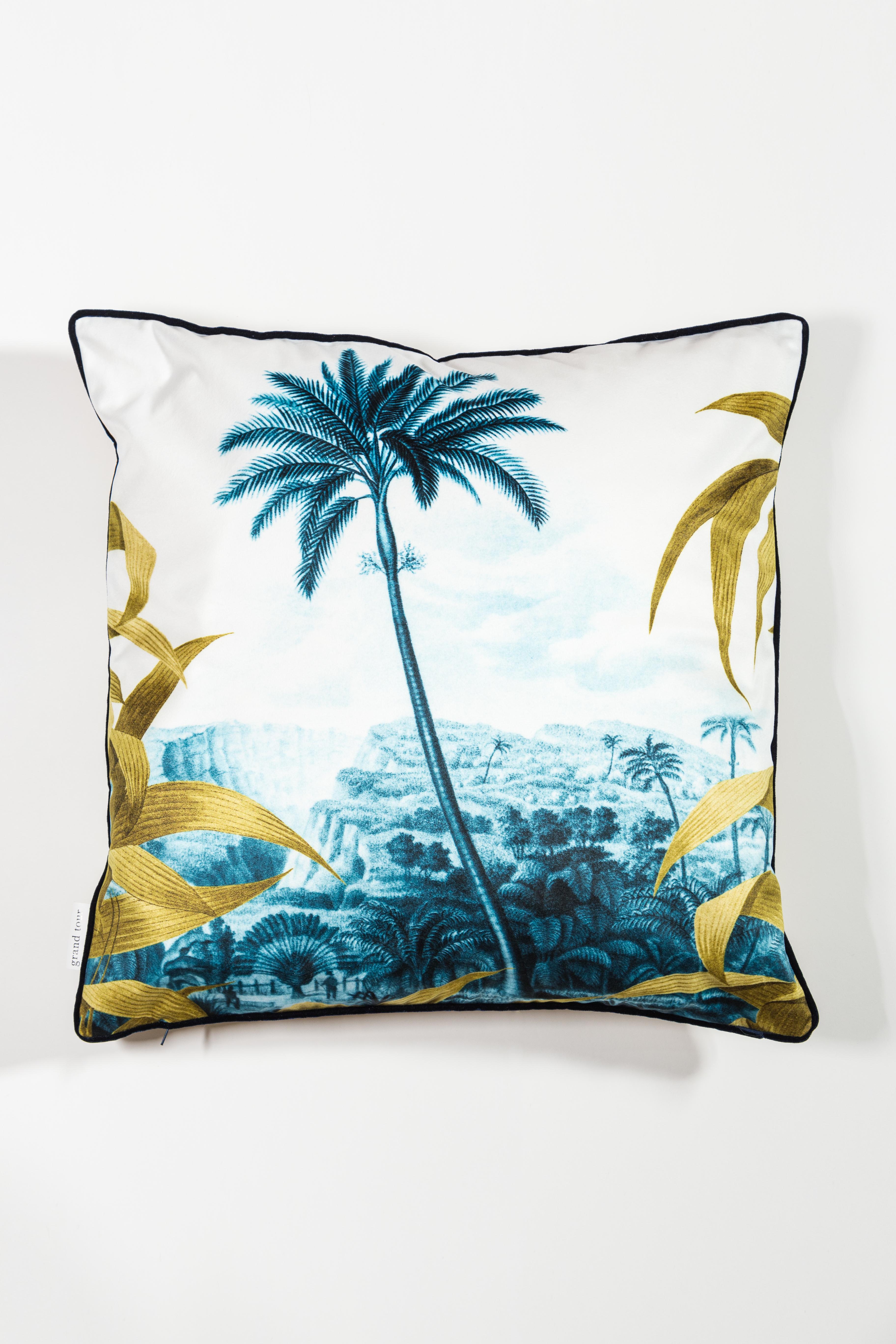 Las Palmas pillows is a set of cushions that evoke the tropical world with illustrations of landscapes near the city of Las Palmas, in the colors of petrol blue, framed by ocher palm leaves. The back is ocher and the edge, also in velvet, is
