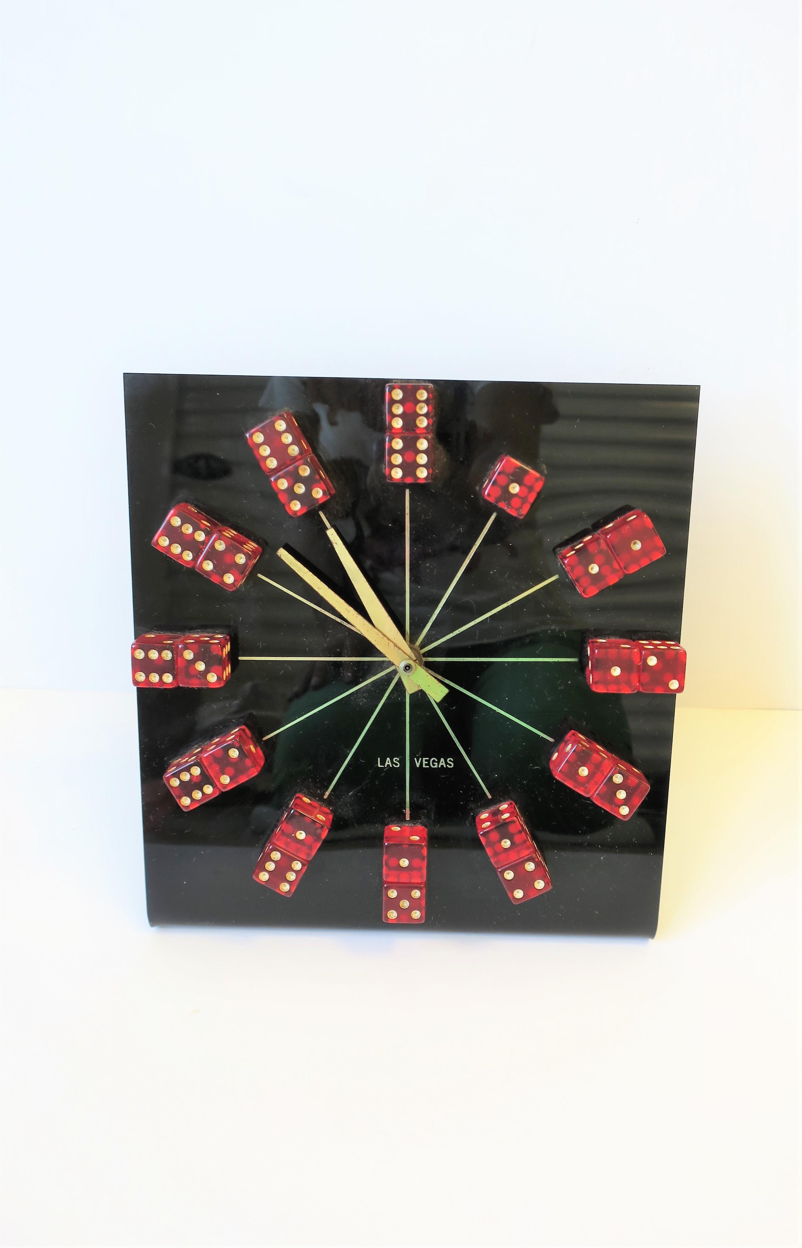 A fun 'Las Vegas' red and white dice faced clock, circa 1970s. Clock has red and white acrylic dice face, brass hands, and black acrylic base, circa 1970s. 

Clock measures: 9.75