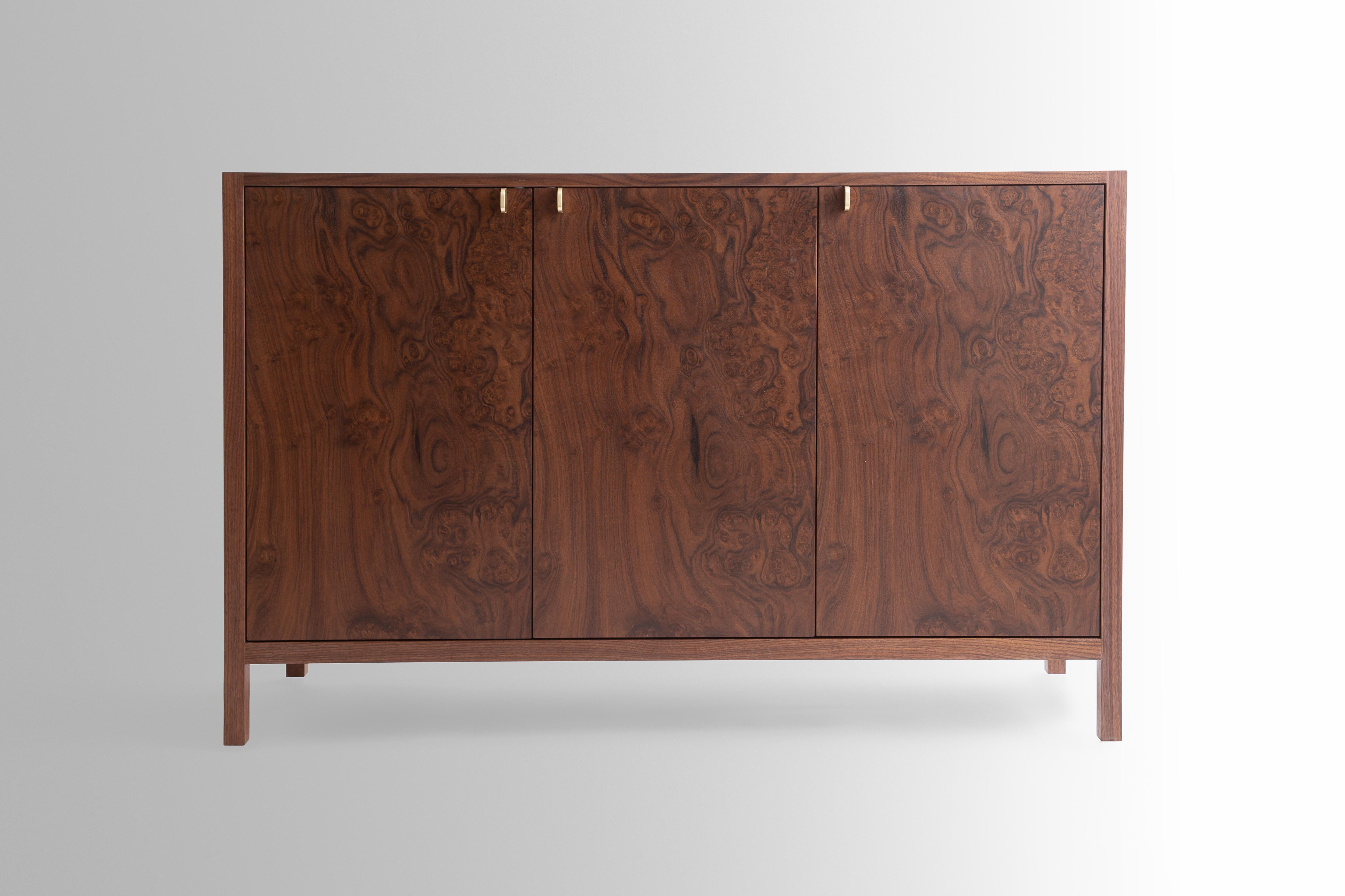 The Laska credenza is built in our Louisville studio using premium hardwoods and thoughtfully selected wood veneers. This piece features custom veneered panels framed flush with solid hardwood edges and legs. The three doors showcase crotch-cut