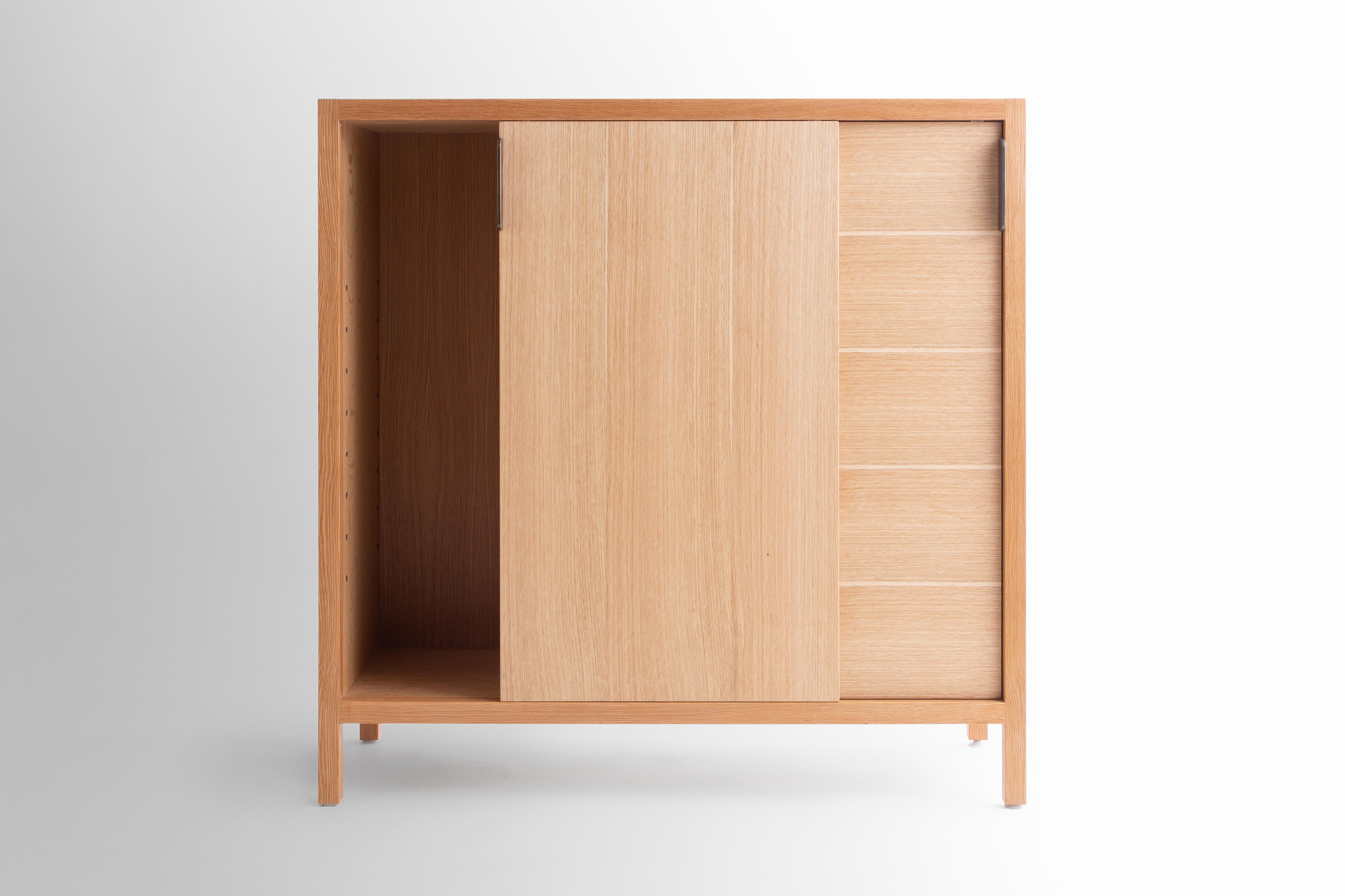 The Laska credenza is built in our Brooklyn studio using premium hardwoods and thoughtfully selected wood veneers. This piece features custom veneered panels framed flush with solid hardwood edges and legs. The sliding doors allow easy access for