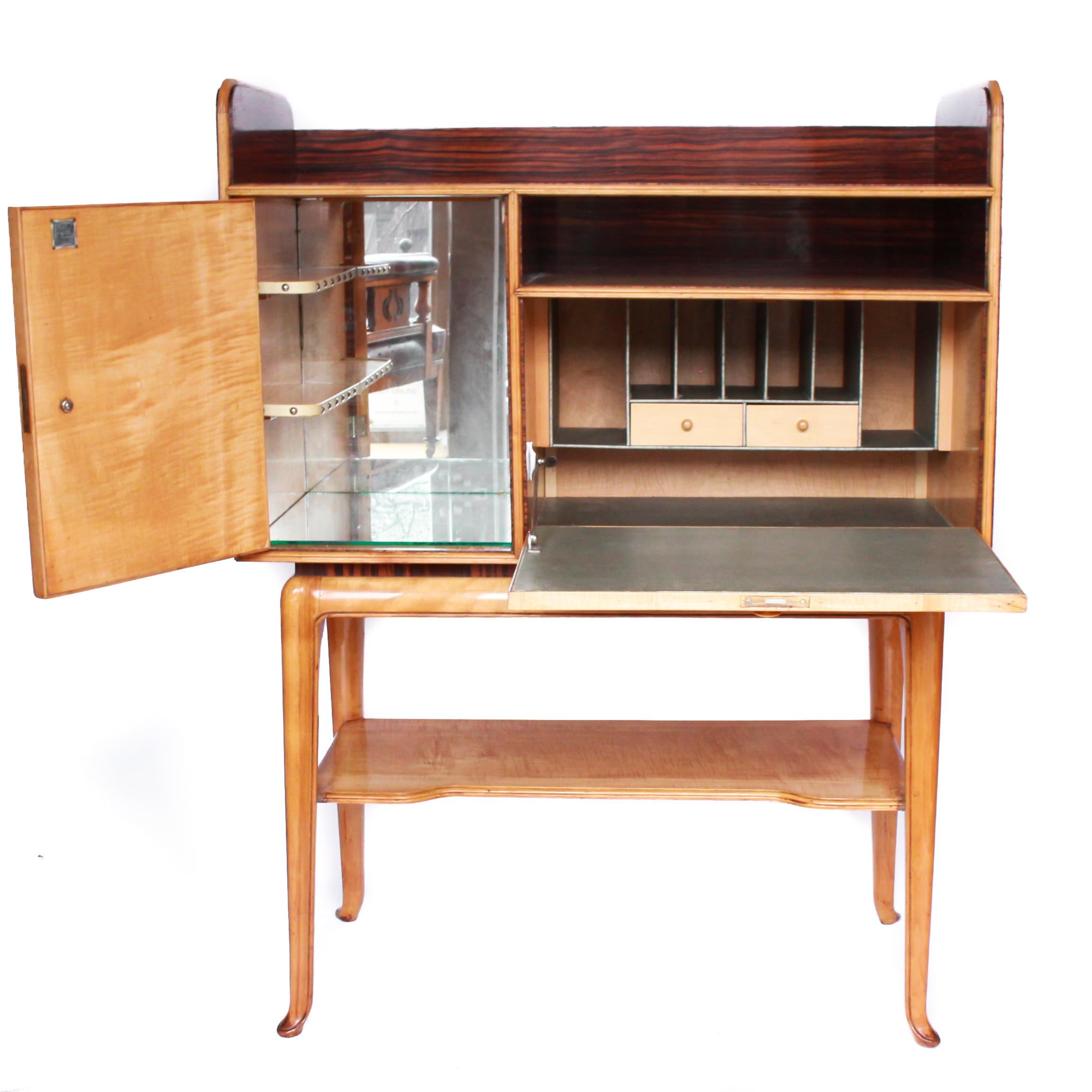 A Macassar ebony and maple bureau and cocktail cabinet designed by Laszlo Hoenig. Cocktail cupboard contains mirrored interior with two small shelves whilst the drop front bureau section consists of two small drawers in the middle of other small