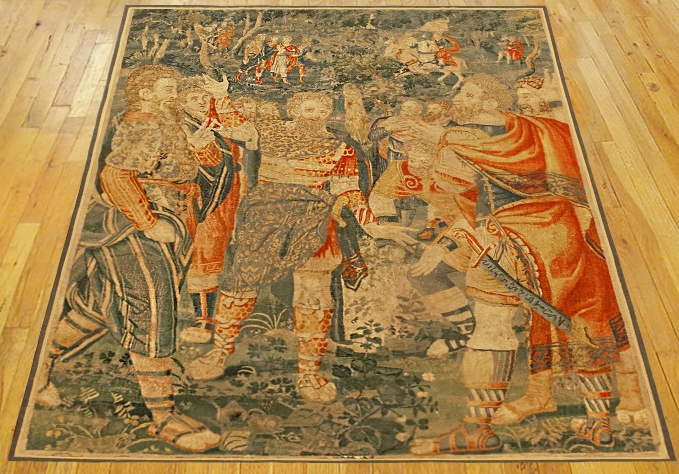 Ein historischer Wandteppich aus Brüssel aus dem späten 16. Jahrhundert mit mehreren bewaffneten Figuren im Vordergrund, die sich auf eine Schlacht vorbereiten, während andere Figuren auf Pferden aus der Ferne näher kommen; in einer bewaldeten