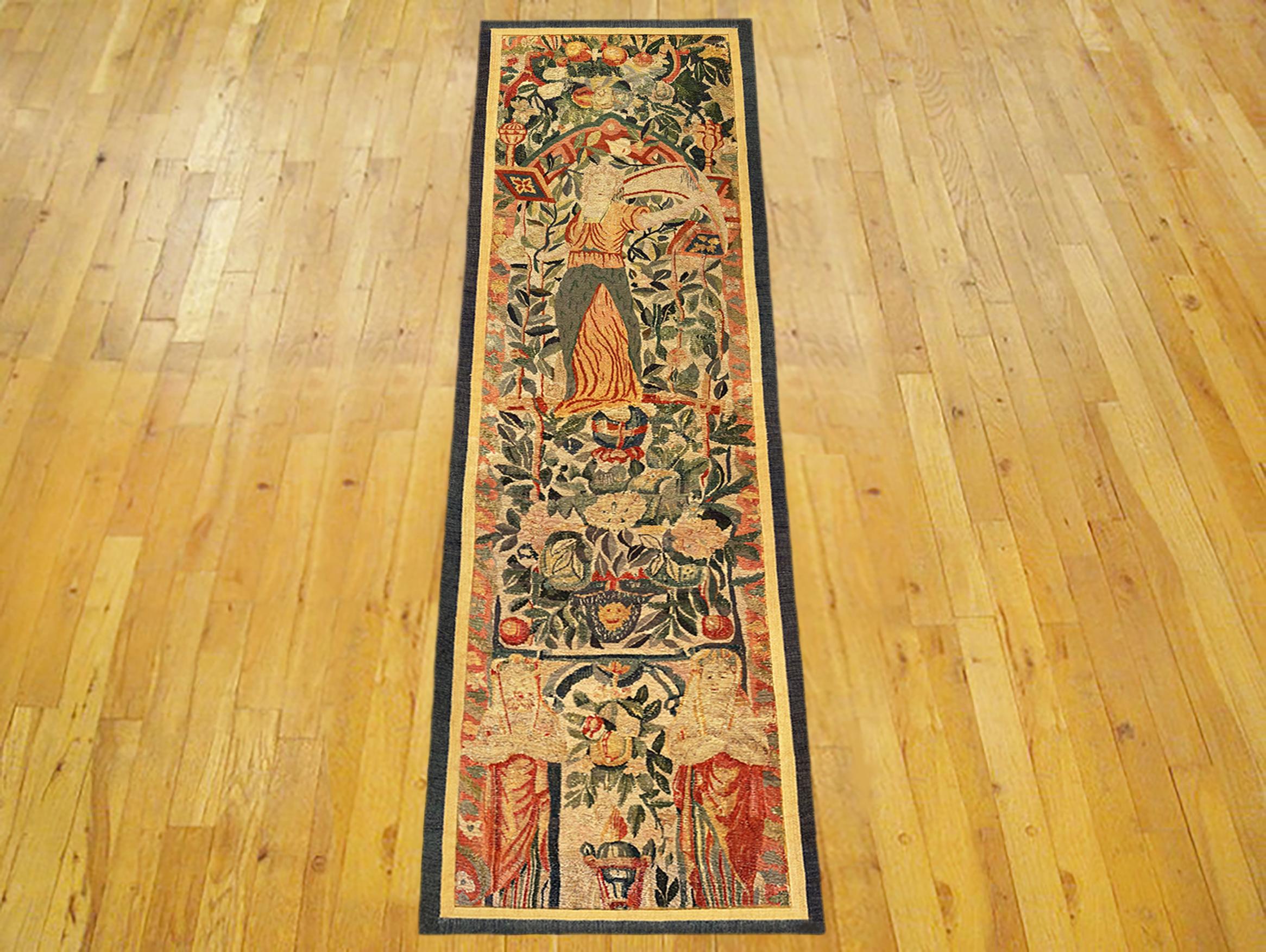 A Late 16th Century Flemish Mythological Tapestry Panel. This vertically oriented decorative tapestry panel depicts a mythological female figure at top, standing within an elaborate floral reserve, with flowers and a portion of an arch at bottom,