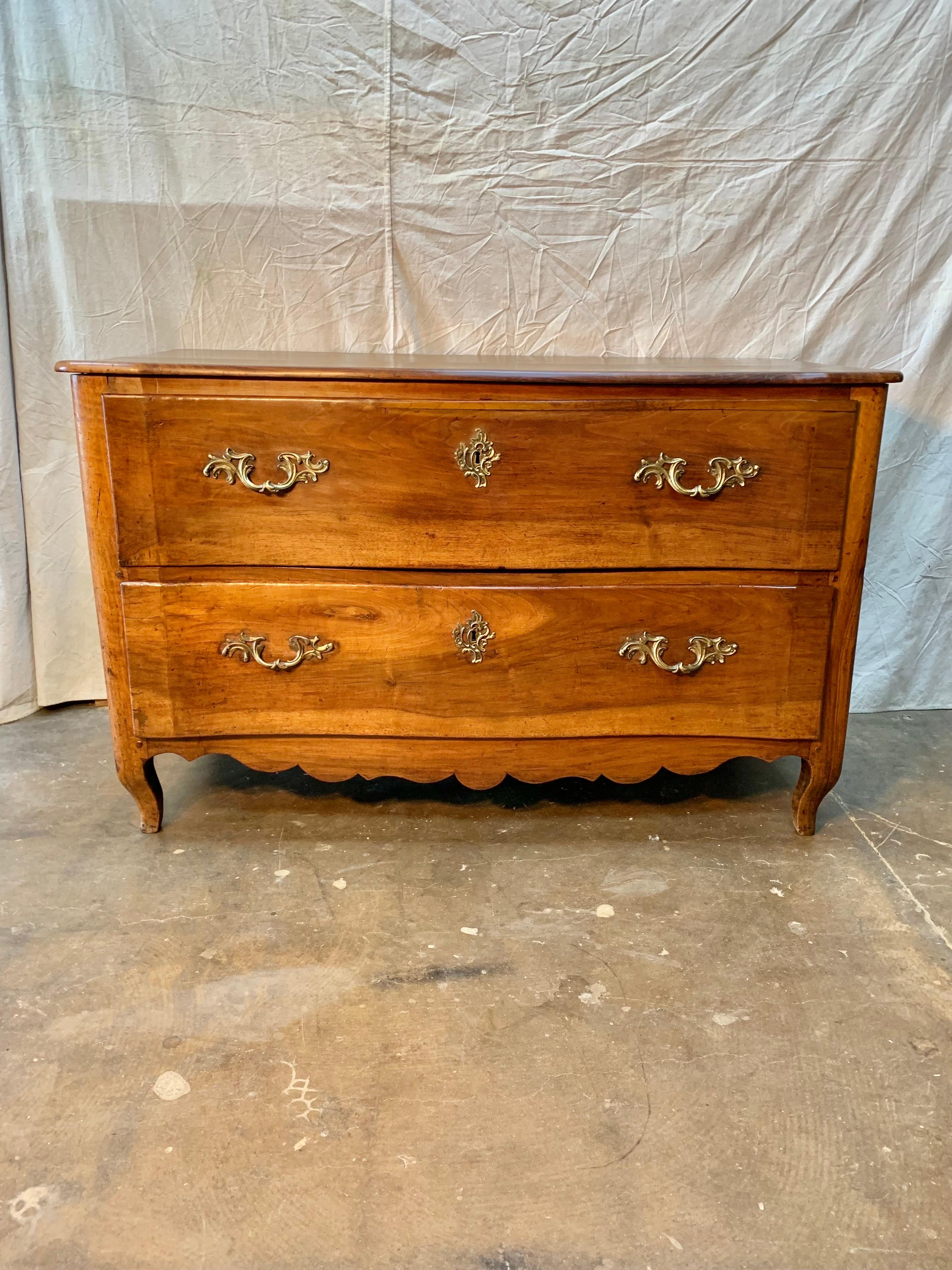 Found in the South of France, this Late 1700s French Louis XV Chest of Drawers was crafted by French artisans from old growth walnut.  The piece features a three planked top resting above two large hand dovetailed drawers.  Each drawer retains its