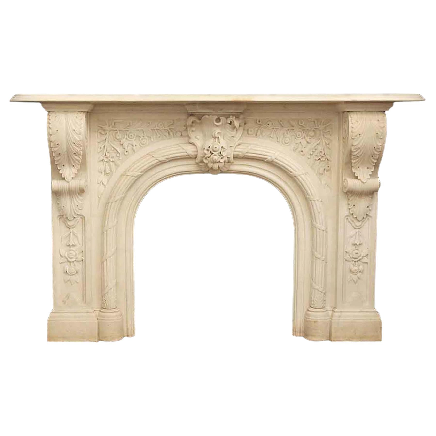 A splendid Victorian arched marble mantel from the early 1800s stands adorned with intricate Baroque center embellishments featuring elegantly carved rosebud florals and leaves. The center arch is adorned with ornate rope and ribbon detailing, while