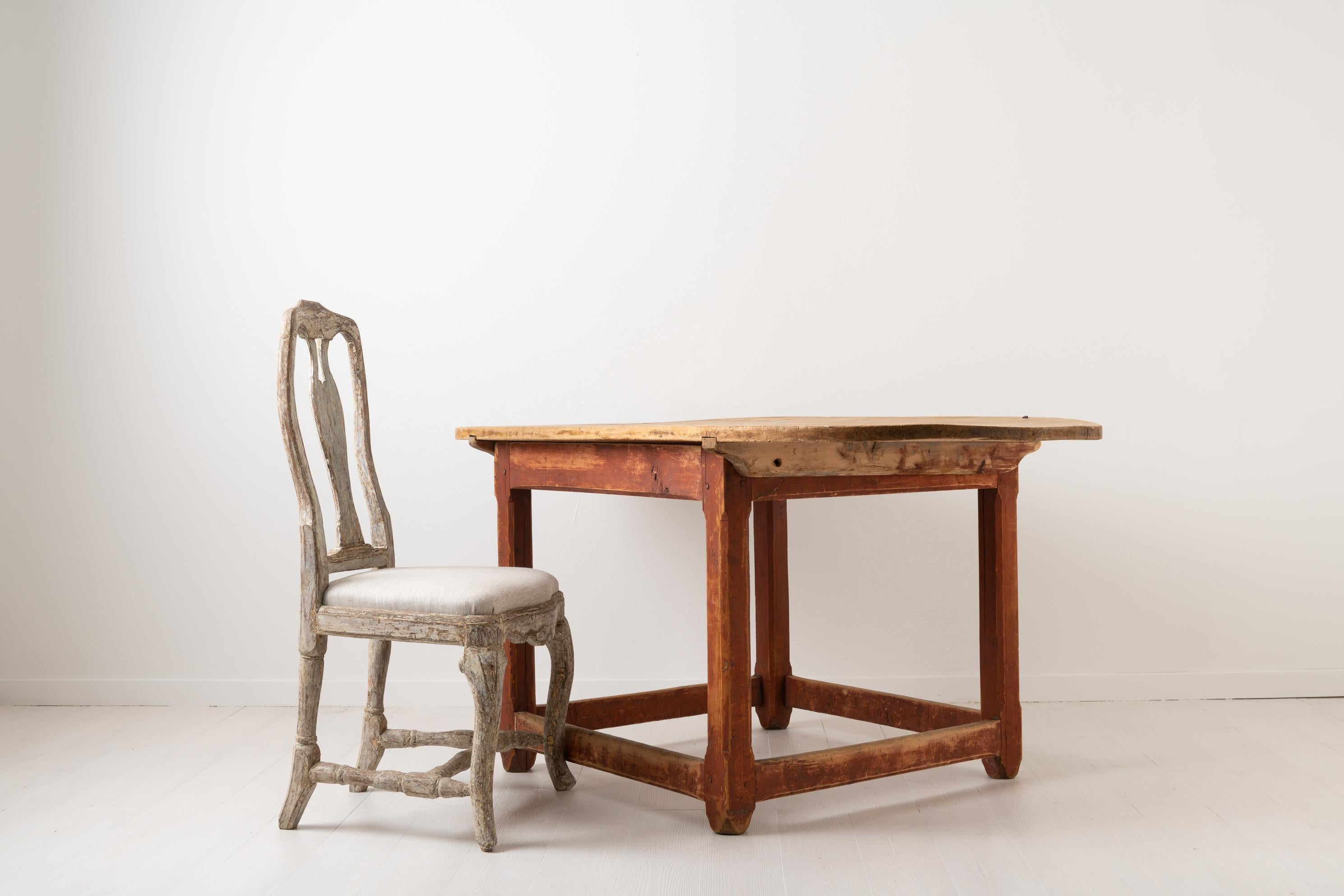 Swedish baroque centre table from the late 1700s. The table is a work table and rustic and primitive in its construction. The detached table top is made from three wooden planks over an inch / 3 cm thick and shows signs of continuous use. The use