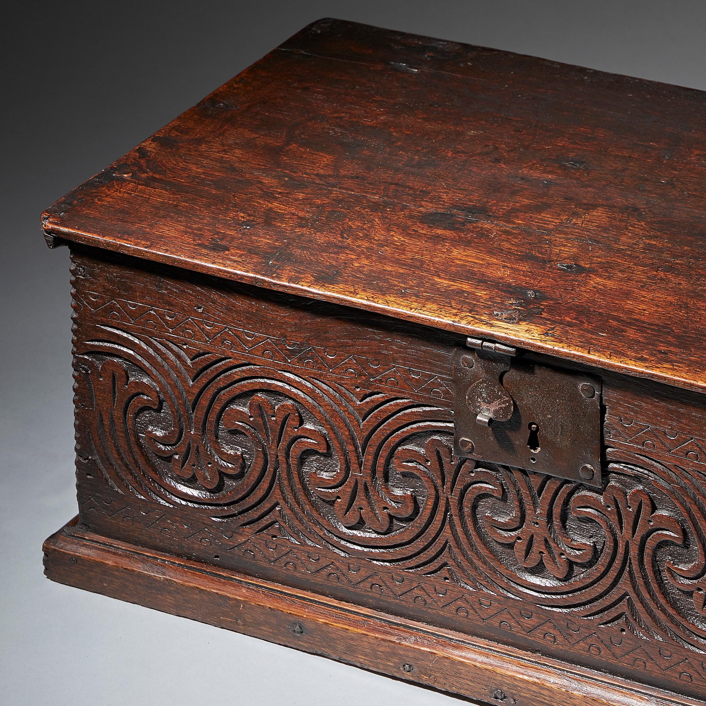 A superb and original late 17th century oak box with excellent and deep lunette carving and well-patinated surfaces throughout, circa 1670-1680. 

Boxes of this small size are rare and rarer still in original condition, including shaped iron strap