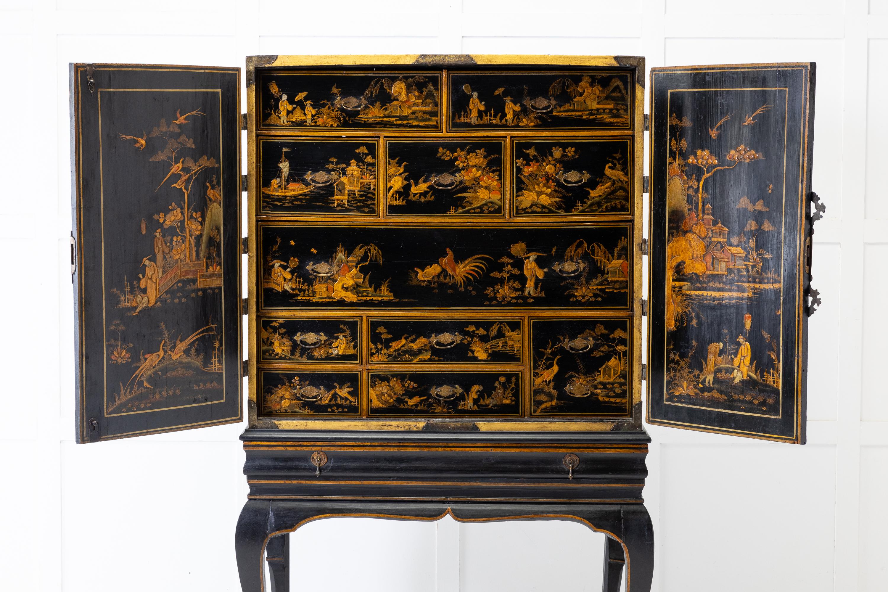 Late 17th Century/early 18th Century black lacquered Chinese Export cabinet on its original stand, which has at one time had careful and sympathetic restoration. Having decoration all over with chinoiserie scenes depicting landscapes and lakes with