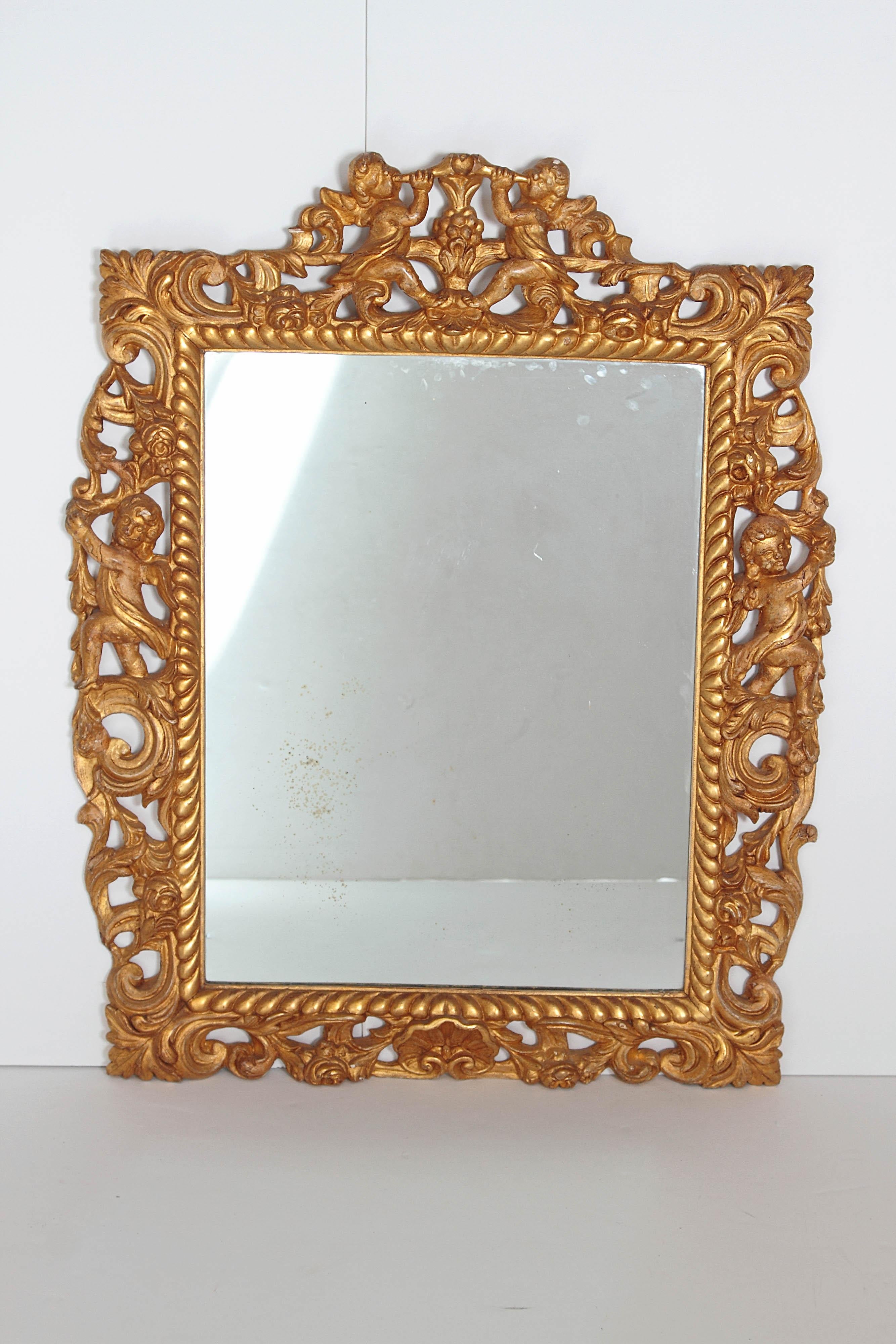 A Charles II carved and gilded wooden frame with replacement plate / mirror glass. Carved gadroon / rope motif around mirror. Frame with overall acanthus leaf carvings with putti left and right of mirror, small shell centered under mirror. Above two
