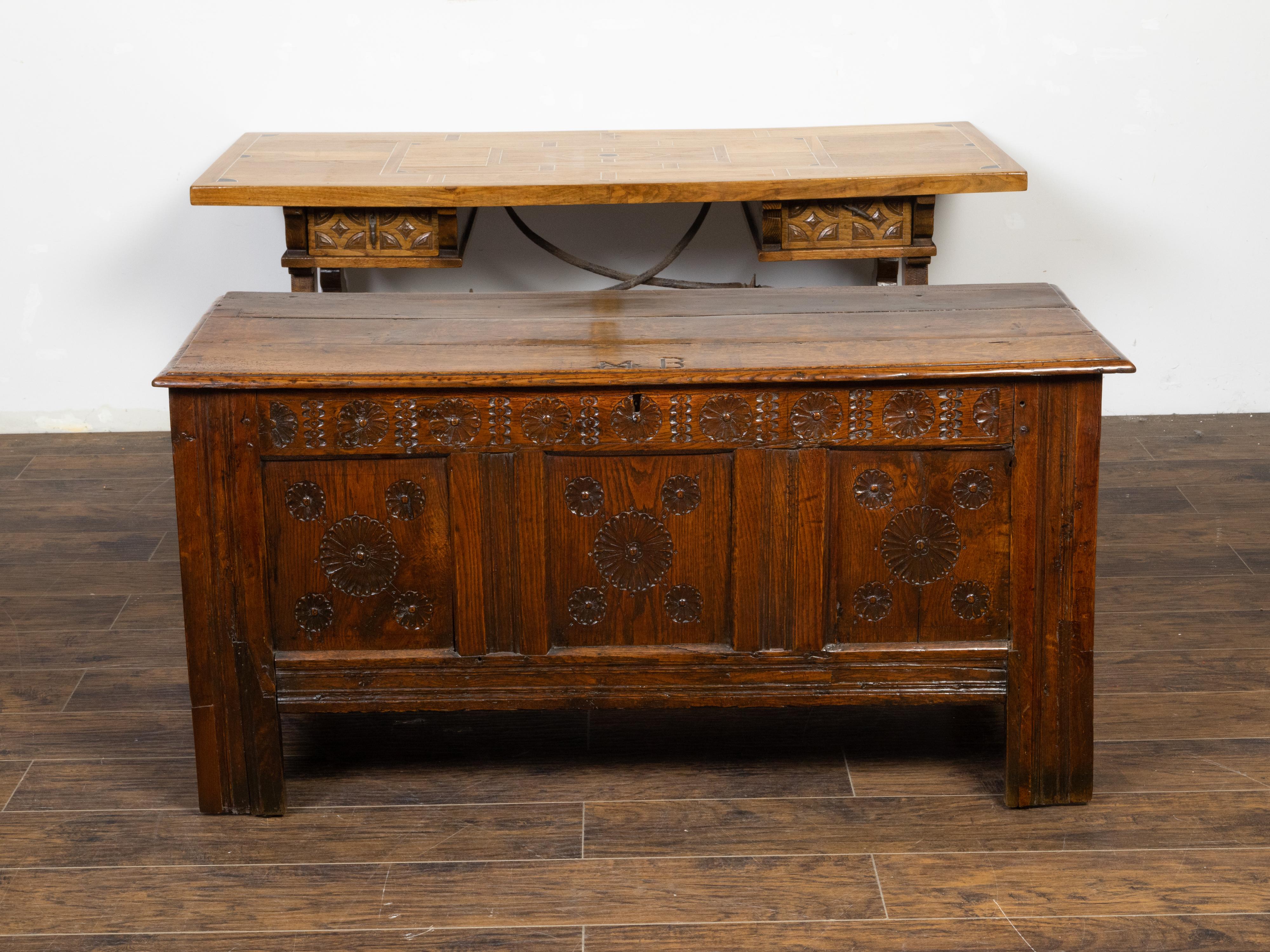 An English oak wedding coffer from the late 17th century, with carved rosettes and iron inlaid monogram. Created in England during the last quarter of the 17th century, this wedding coffer features a rectangular planked top inlaid in iron with the