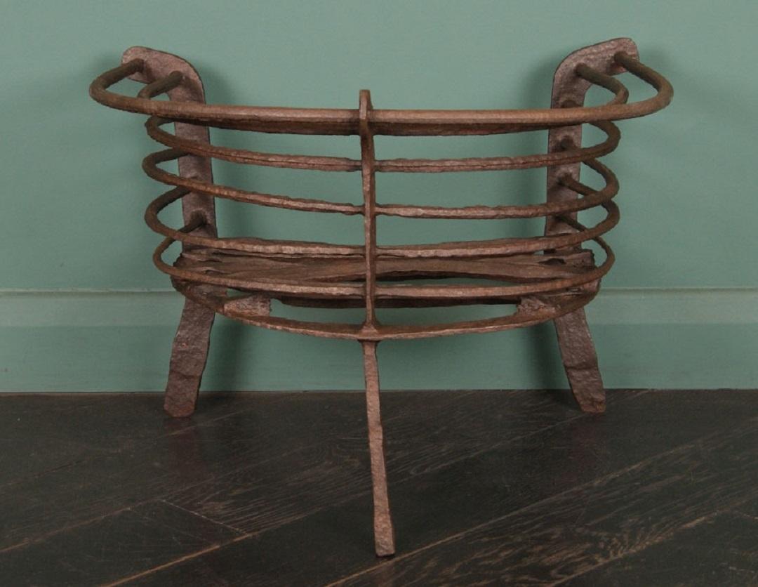 Un cesto da fuoco semicircolare in ferro battuto della fine del XVII secolo. Le barre di fuoco rotonde formano l'involucro e il piano di cottura rudimentale con griglia di fuoco rivettata. Finitura a cera.

Circa 1690