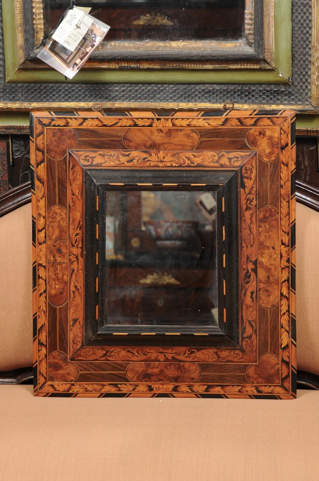 A late 17th century French Inlaid rectangular mirror featuring foliage marquetry in walnut, burled elm and maple. The marquetry on this mirror is an example fine craftsmanship from this time period. The ebonzied detail gives a beautiful contrast to