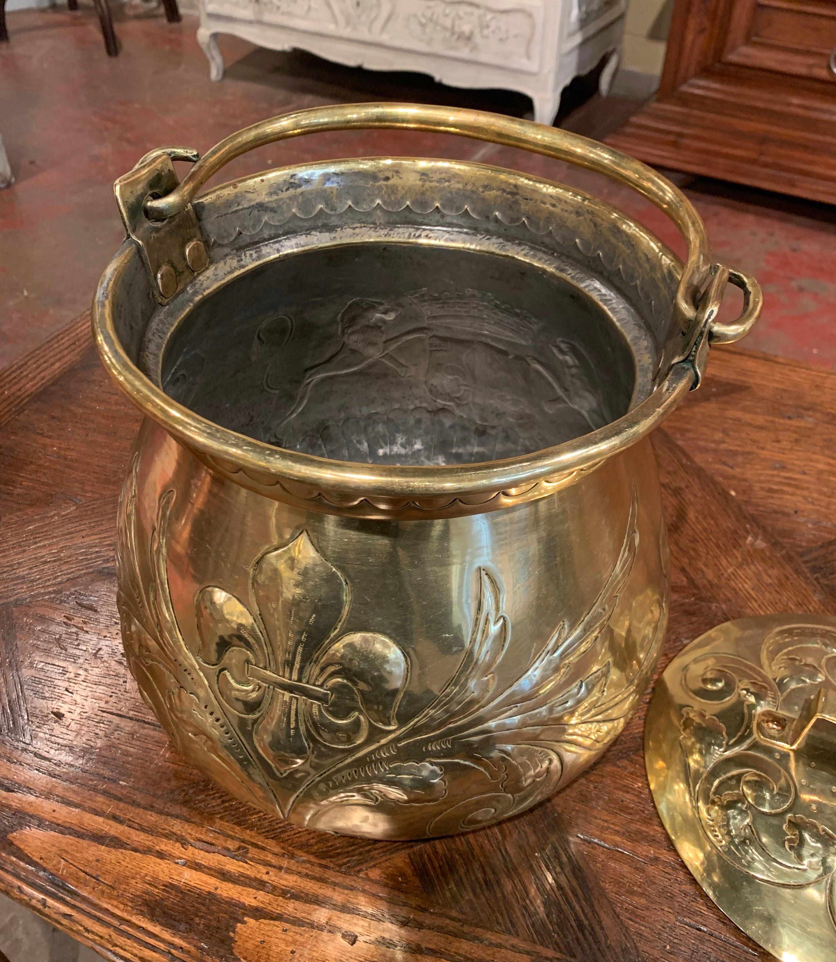 This period antique cauldron with original removable lid was created during the reign of King Louis XIV circa 1690, crafted of brass, the round dish features repousse decor of Fleur de Lys and the coat of arms of the kingdom of France flanked by