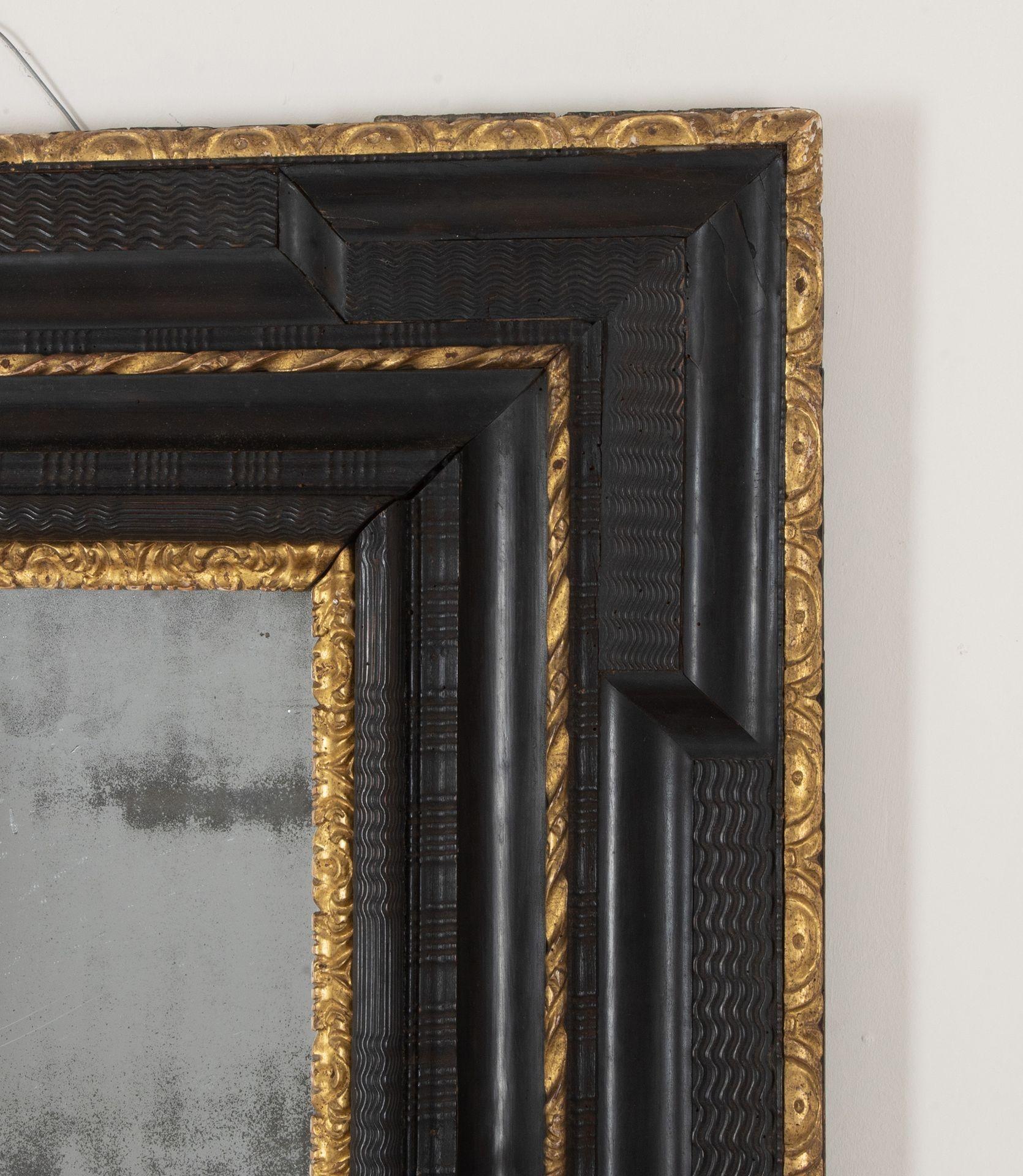 Splendido specchio in legno dorato, ebanizzato e intagliato, della fine del XVII o dell'inizio del XVIII secolo. Il piatto rettangolare di mercurio, meravigliosamente foxed, è inserito in una sottoveste di legno dorato intagliato e circondato da