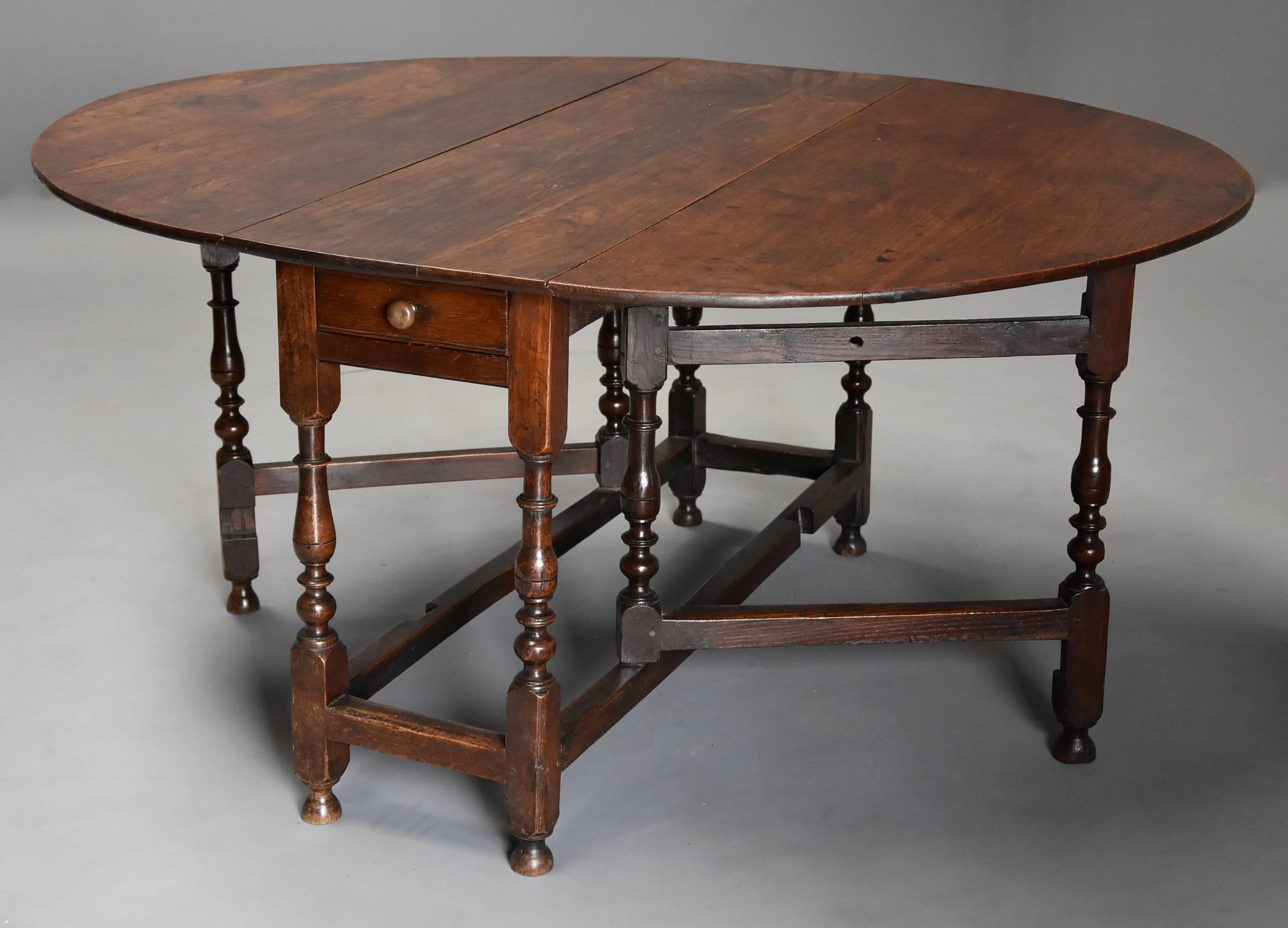 A late 17th century (circa 1700) oak gateleg table of good, versatile size with fine patina.

This table consists of a solid oak top with one drawer below (not original) and is supported by finely turned baluster legs.

This table is in