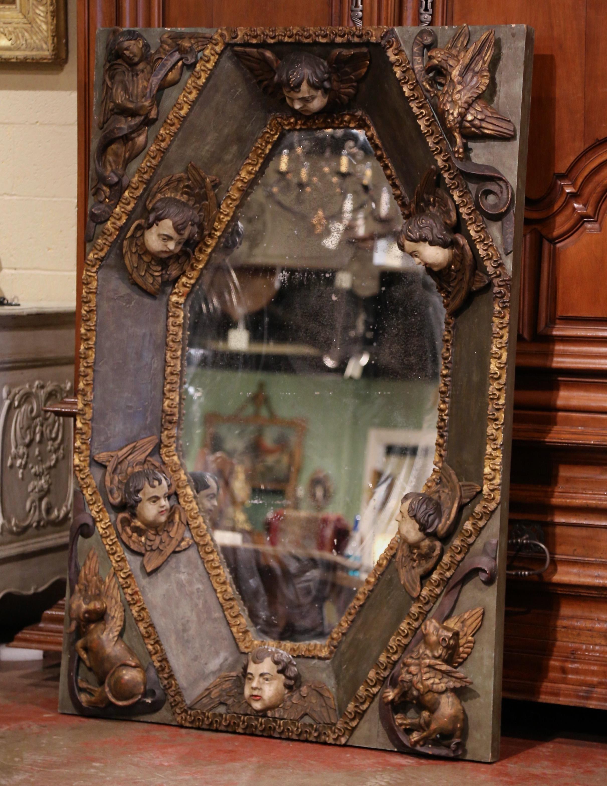 Crafted in 17th century Spain circa 1670, or probably coming from a private chapel ceiling, the interesting mirror features six carved cherub head figures around the recessed frame, and embellished with high relief motifs in the corners including