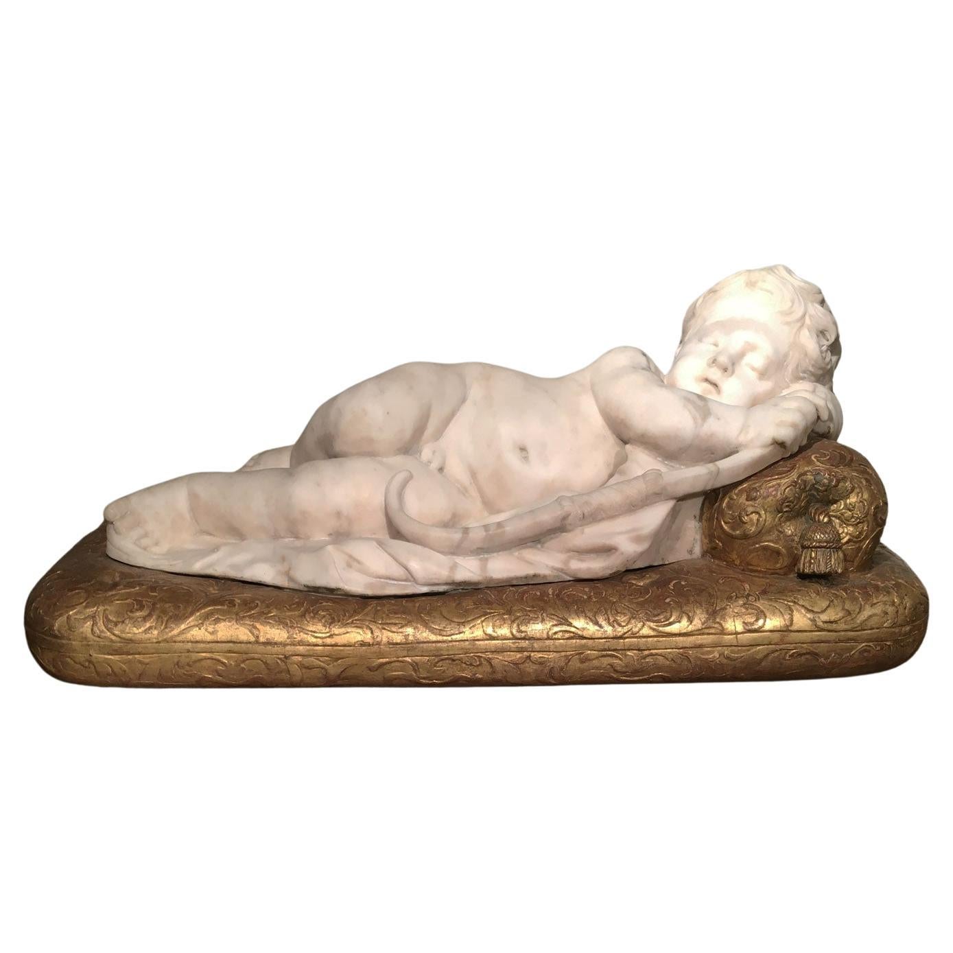 Escultura de Cupido desnudo infantil tallada en mármol blanco de finales del siglo XVII sobre base dorada