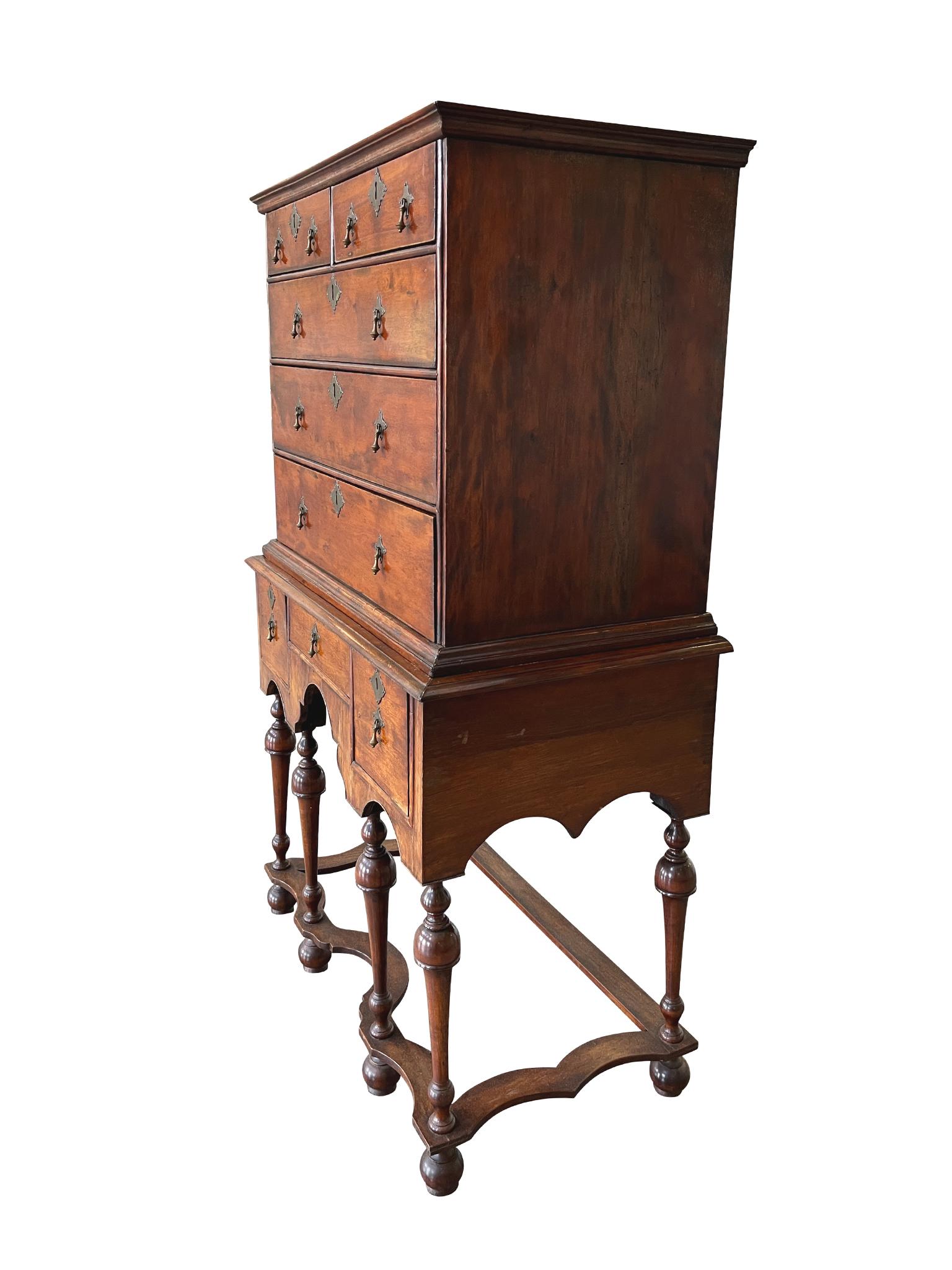 Realizzata a mano intorno al 1690, questa cassettiera in due parti in mogano rappresenta lo stile William & Mary con la sua combinazione di forme curve e lineari. La metà superiore è composta da 2 cassetti piccoli e 3 cassetti a tutta lunghezza,