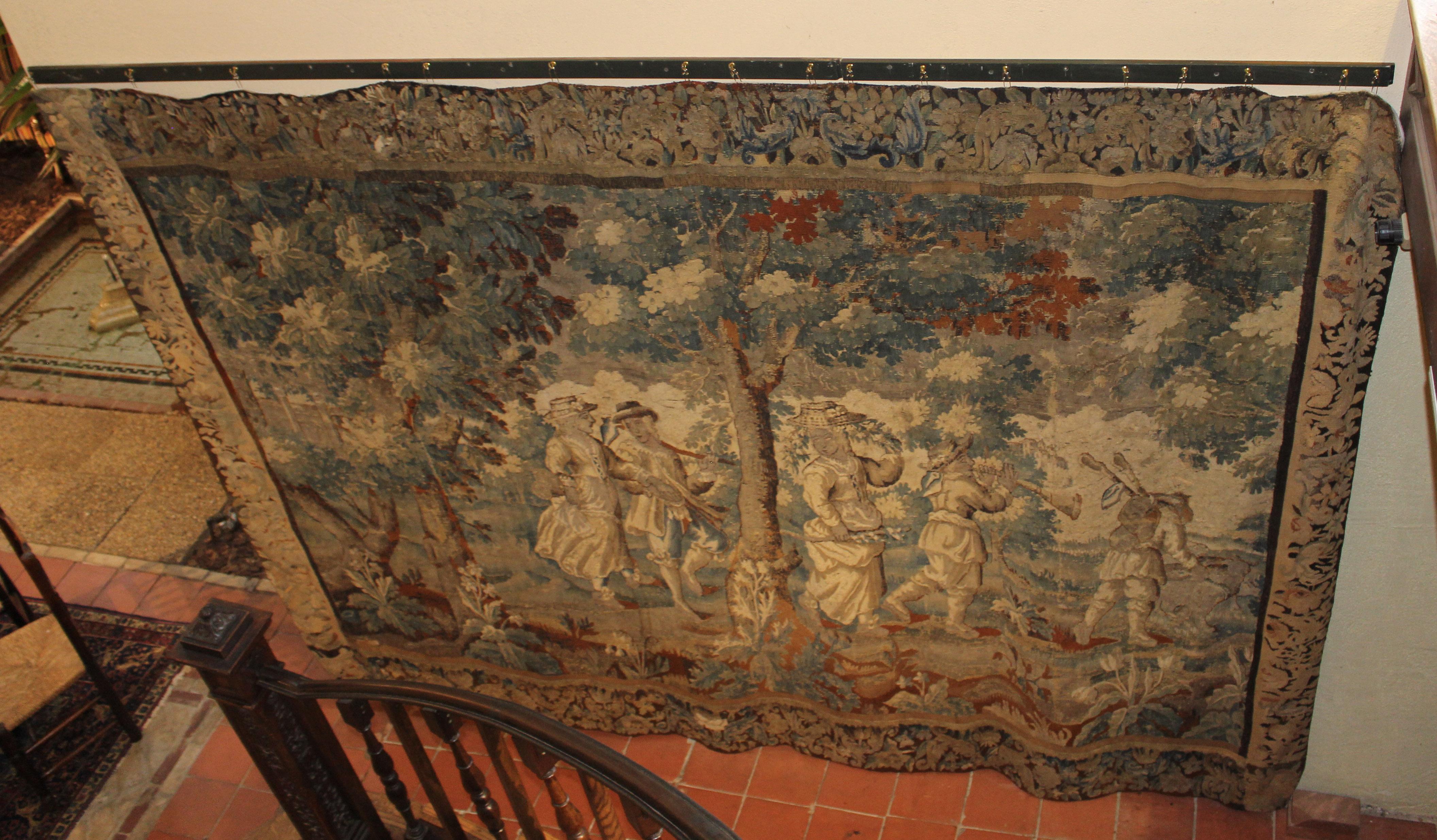 Late 17th to early 18th century Aubusson tapestry, Continental. Displaying a Spring procession into the garden with implements, etc. Likely part of a series or even larger tapestry given the contrasting borders. Faded, as expected given the age.
98