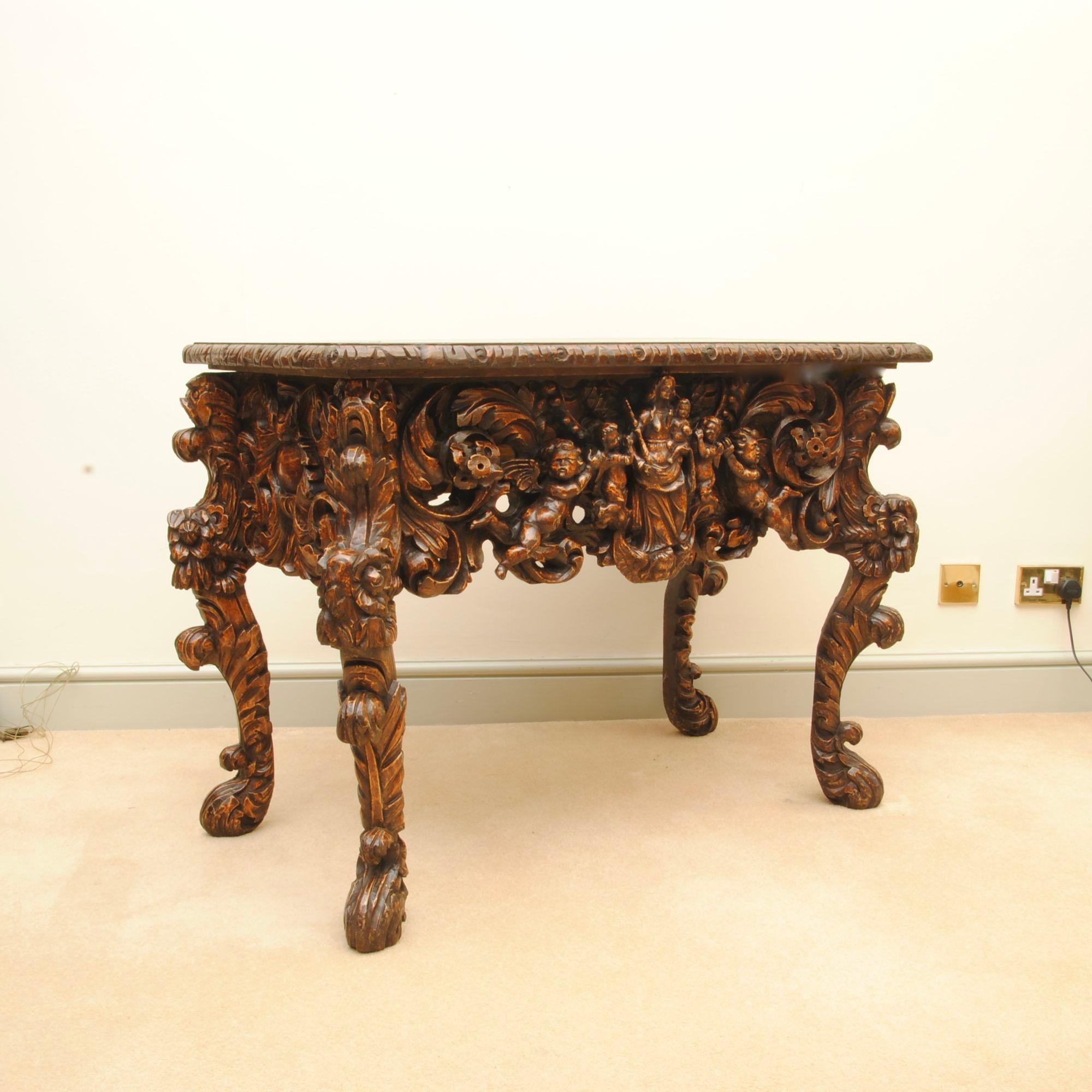 A rare early 18th century Dutch carved console table with cabriole legs. The finely decorated frieze with figures and flowers surrounded by scrolling acanthus.