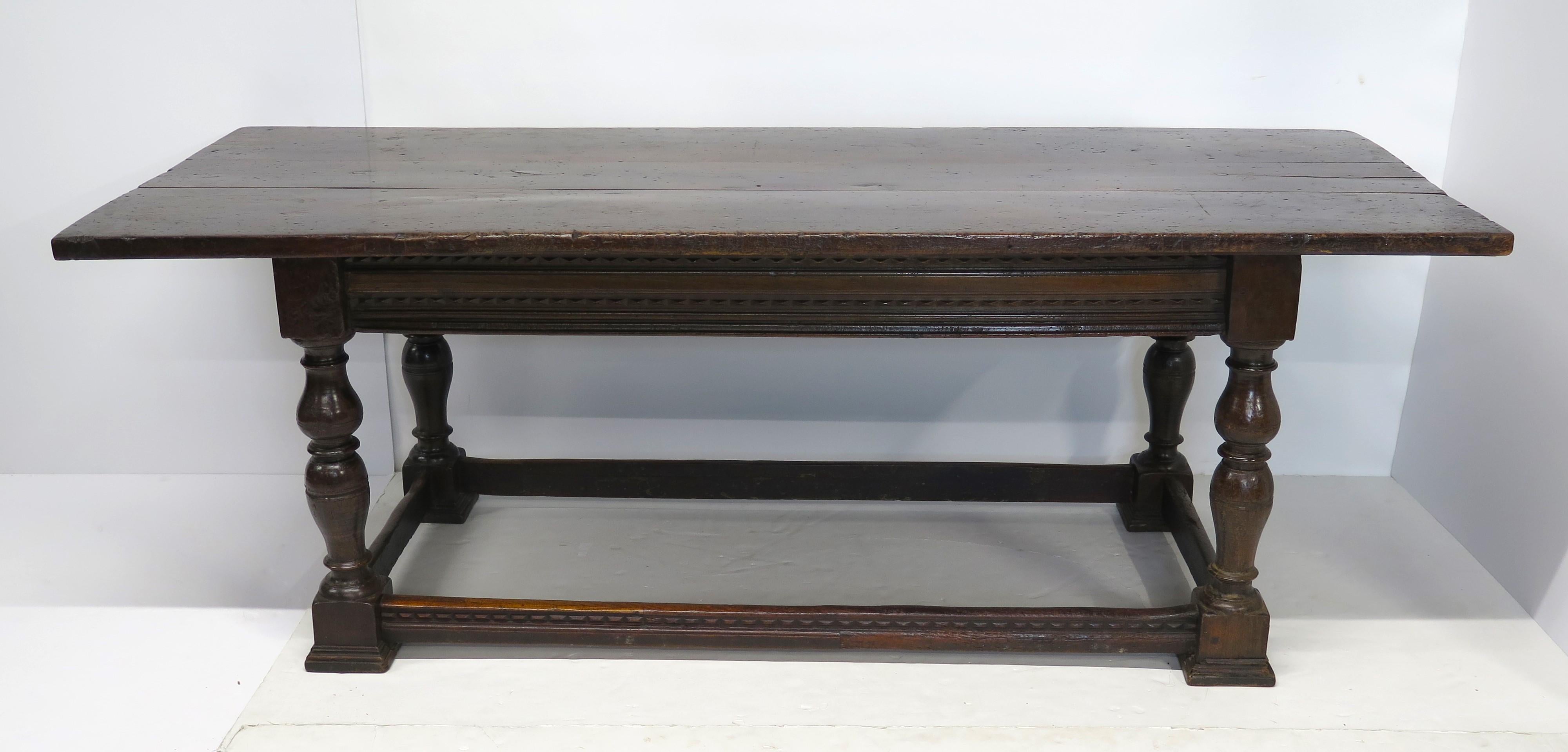 a heavy oak refectory table with stretcher base, it has a triple plank top, turned baluster legs support the apron of the table, these sorts of tables were used as communal dining tables, together with benches or stools, as seating in schools or