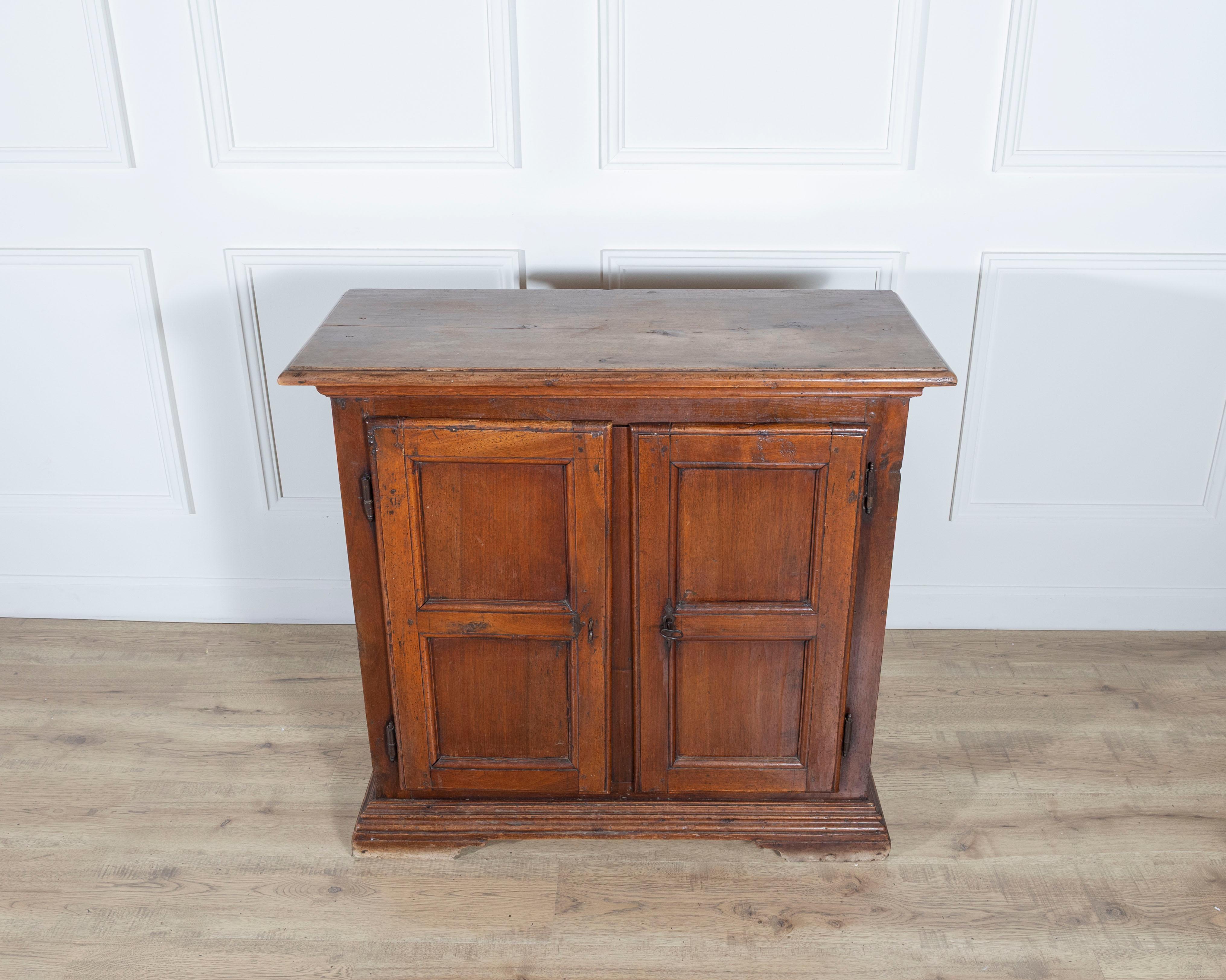 A rare small sideboard from Northern Italy, dating from the late 17th to early 18th century, crafted entirely in solid walnut. This charming piece showcases the simplicity and elegance of early Italian rural craftsmanship, with clean lines, framed