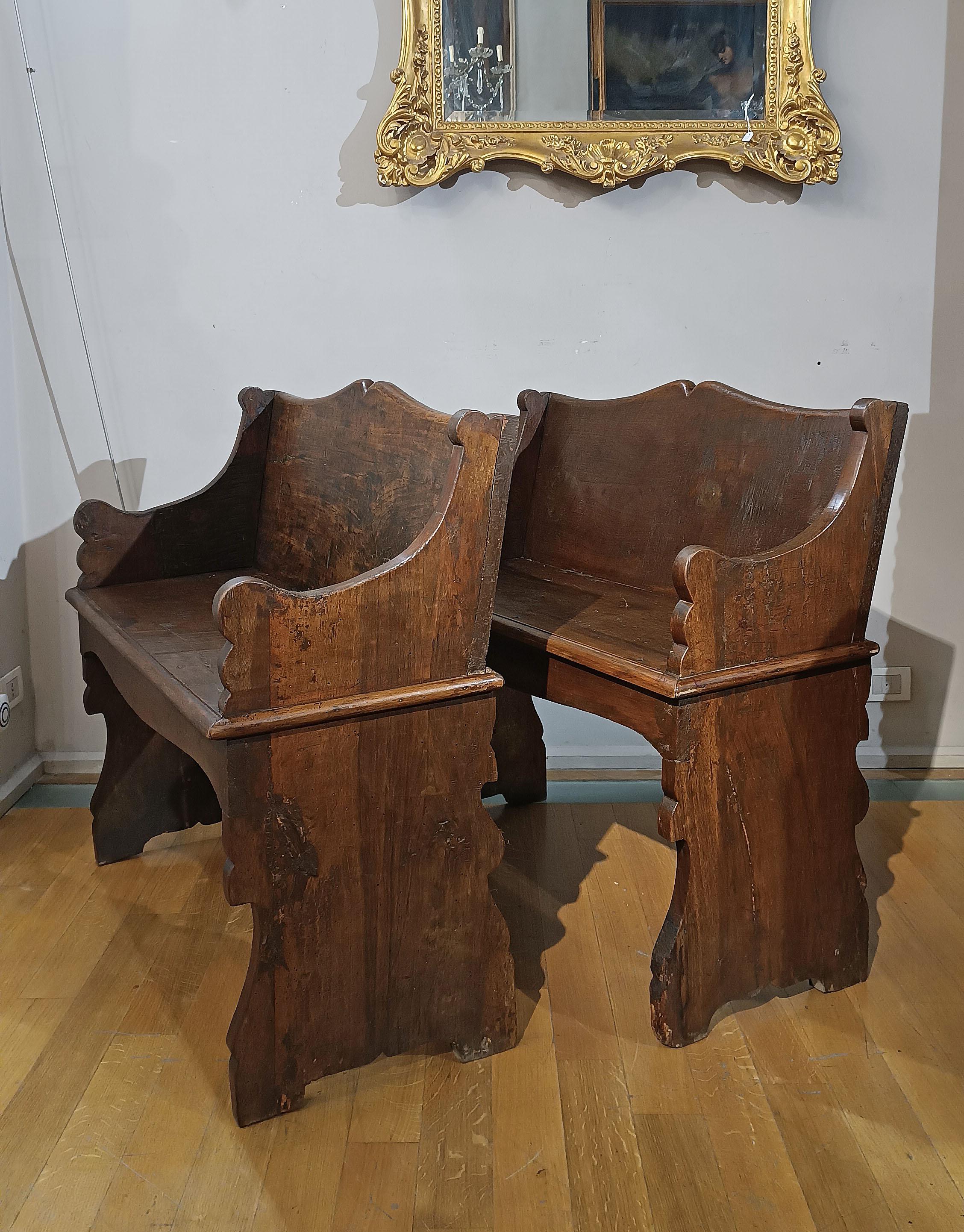 Elegant pair of benches of small dimensions, made of solid carved walnut. The backrest, sides and legs feature a refined carving with molded scrolls, which gives a touch of class. Both the backrest and the seat are spacious and comfortable. This