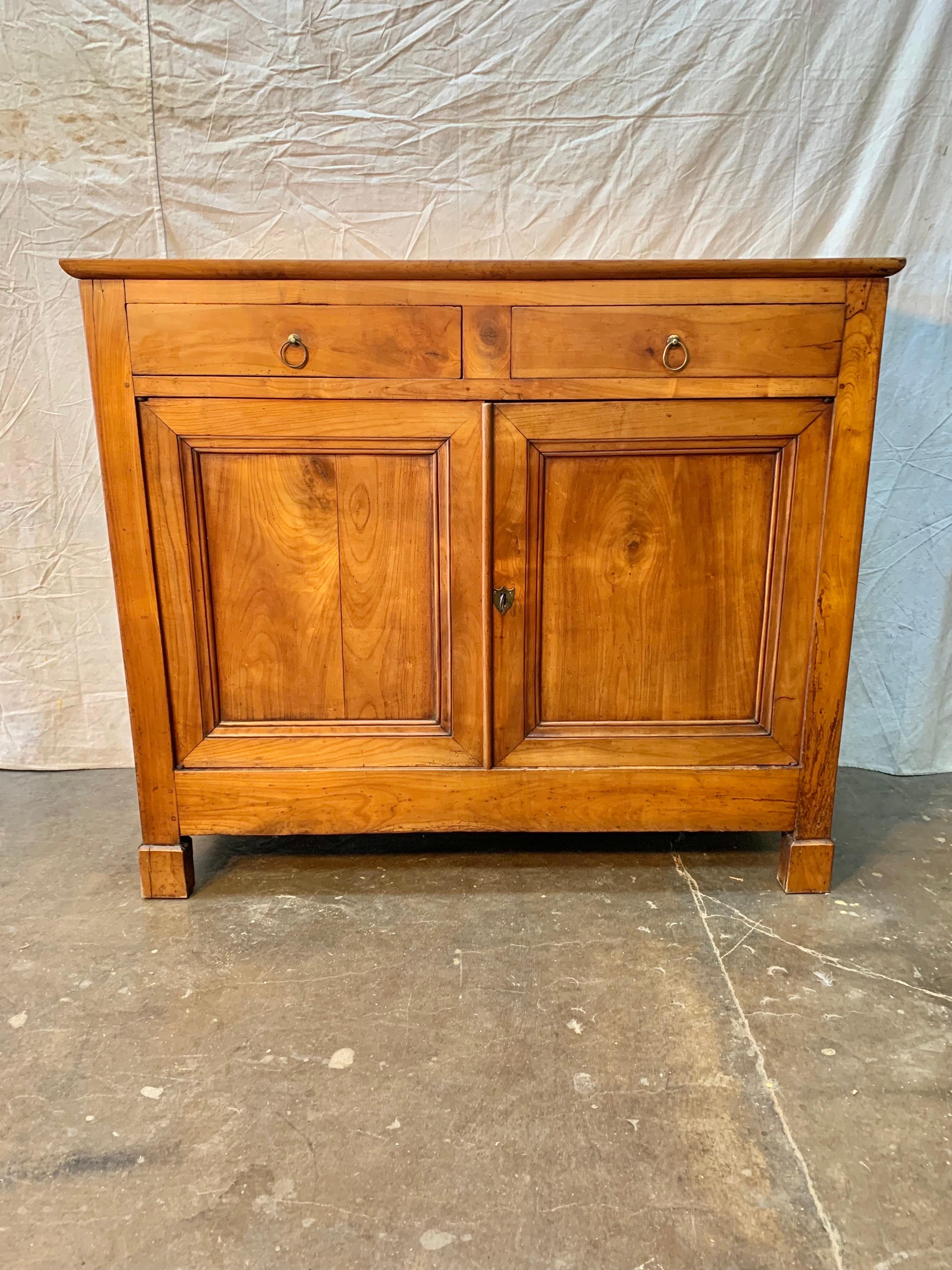 Found in the Pays de la Loire Region of France, this French Louis Philippe buffet or sideboard, was crafted from mixed wood consisting of old growth cherry and pine side panels. The mixed woods create a unique color variation to the piece. This