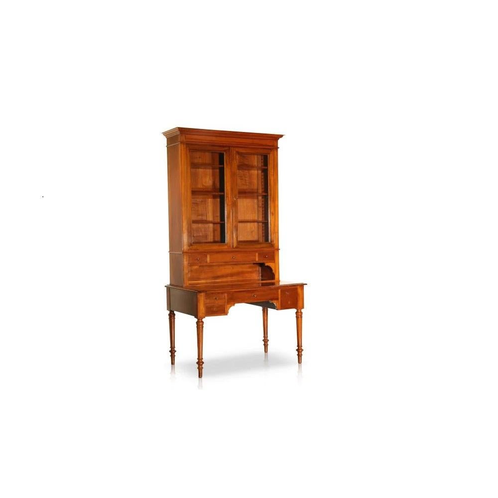 This grandiose Secrétaire features walnut composure and downplayed Louis XVI style legs. Featuring a glass front bookshelf/ display cabinet, the lower half of this piece was made to be used as a desk, though could also be used as a larger display