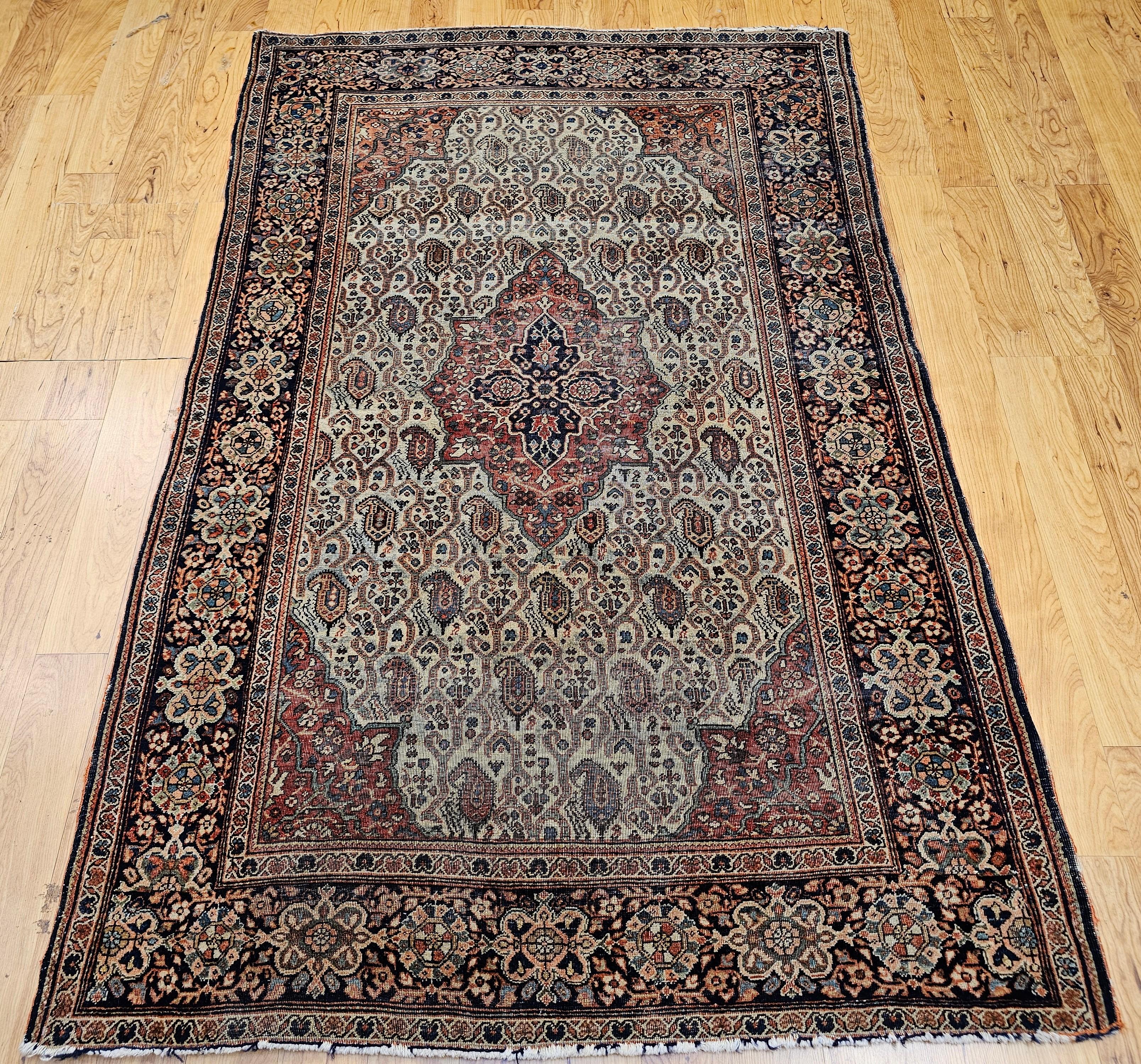 Alfombra persa Sarouk Farahan de finales del siglo XIX con diseño paisley en campo verde pálido y borde rojo óxido.  La alfombra tiene un diseño paisley muy singular en toda la superficie conectado mediante líneas de desplazamiento en un campo de
