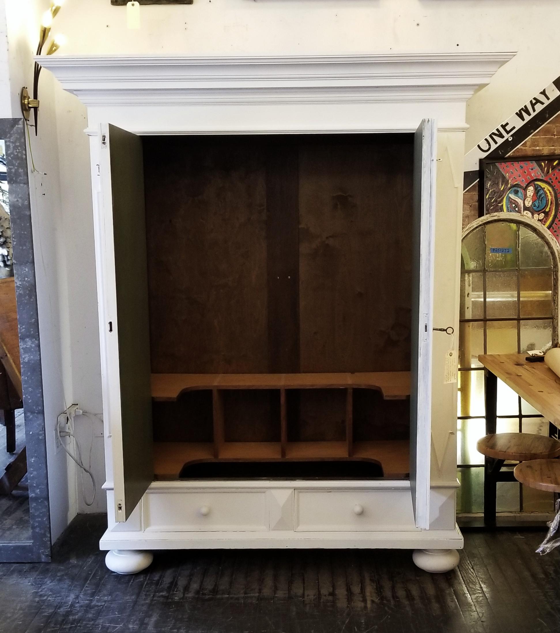 This is a beautifully restored roomy late 1800s armoire cabinet that has been painted white on the outside. Custom built shelves have been added towards the bottom of the cabinet. The clothing bar is missing, but the holes are there to add one. The