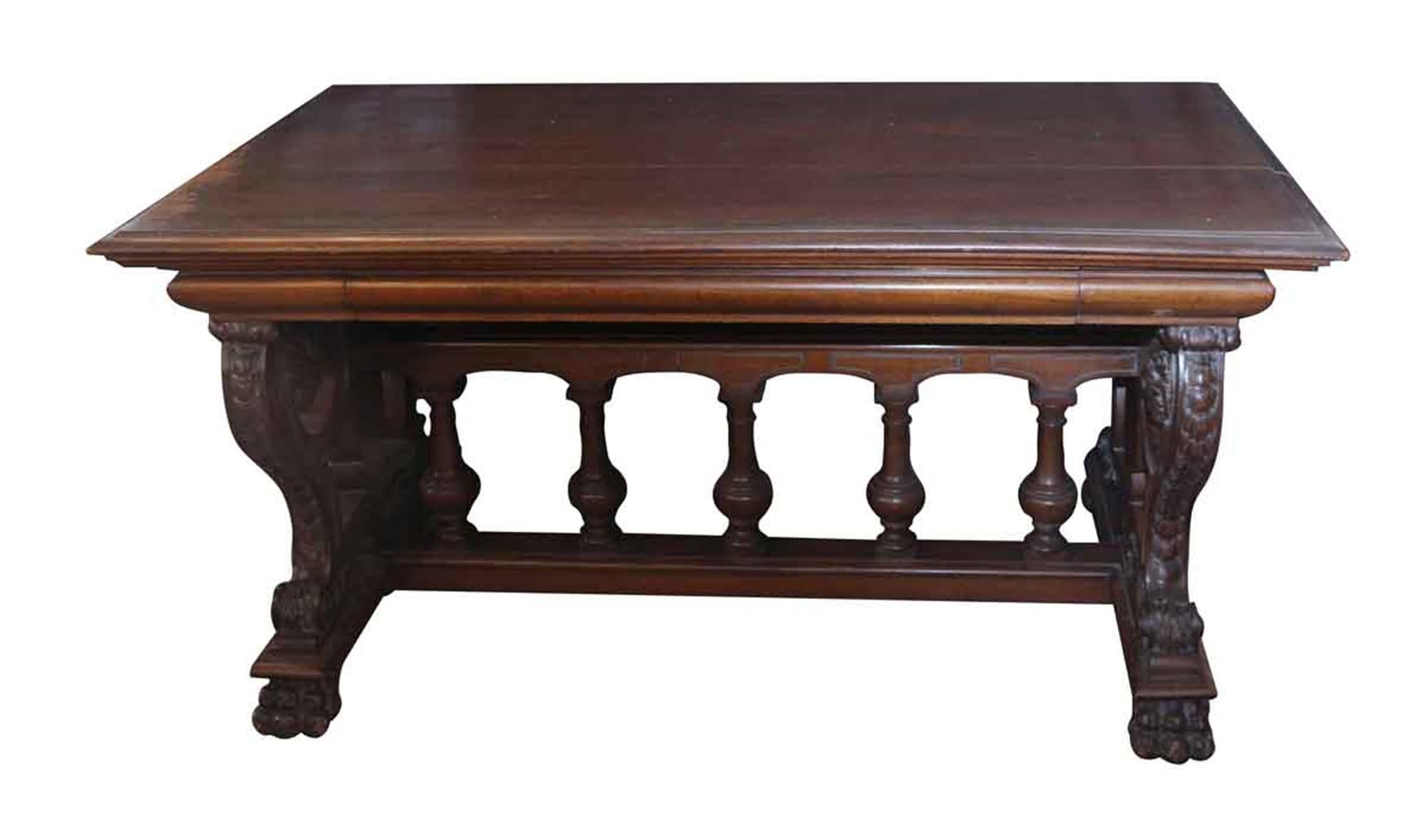 Dark wood tone RJ Horner claw foot library table with ornate carvings throughout the legs and base from the 1880s. The top has a crack in the center and there is some minor wear from age and use. This can be seen at our 2420 Broadway location on the