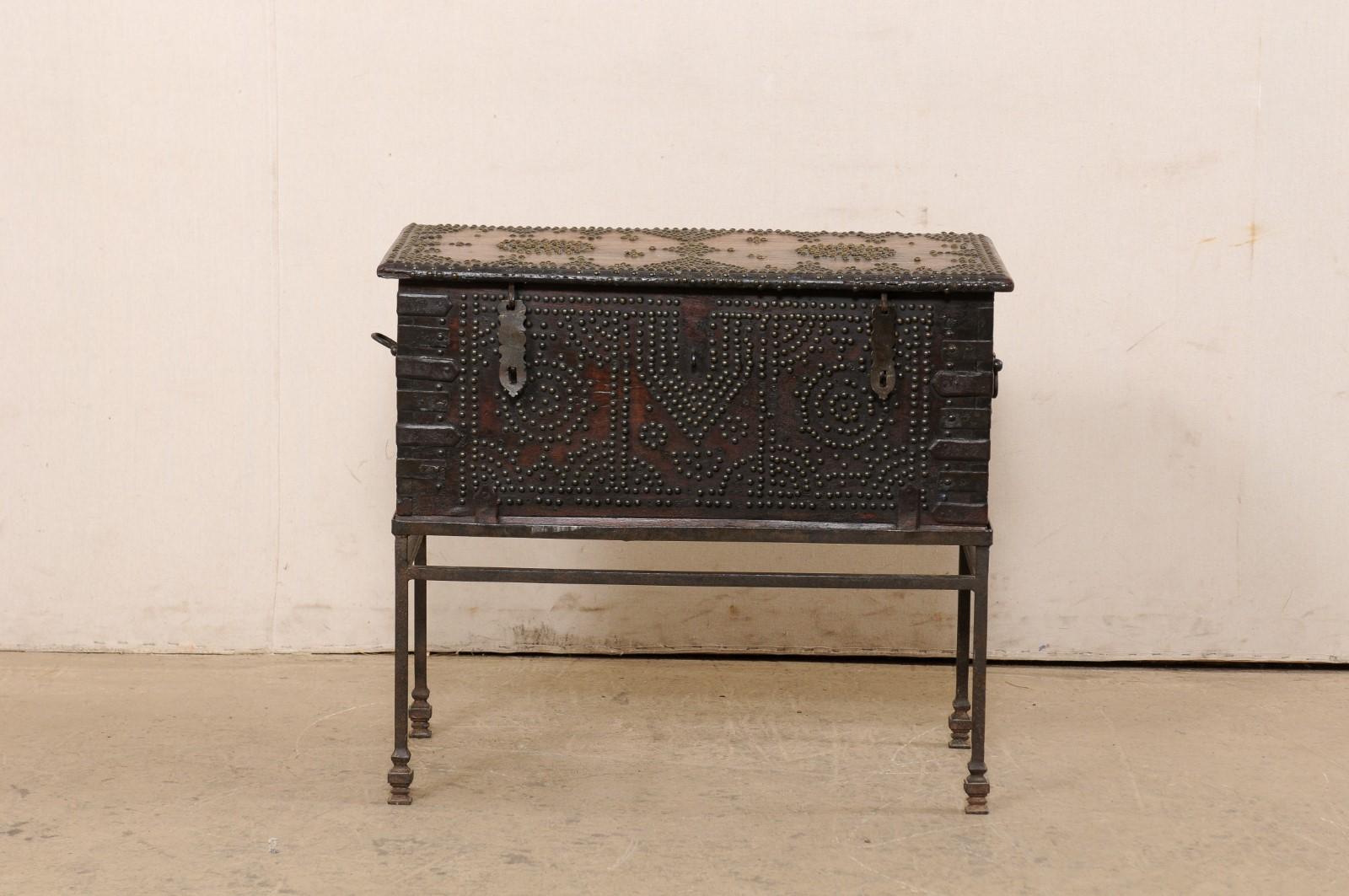 A British Colonial rosewood trunk from the turn of the 18th and 19th century. This antique English trunk, which would also function beautifully as a small table, has been nicely adorn with a patterning of studs (including circular medallions, cross