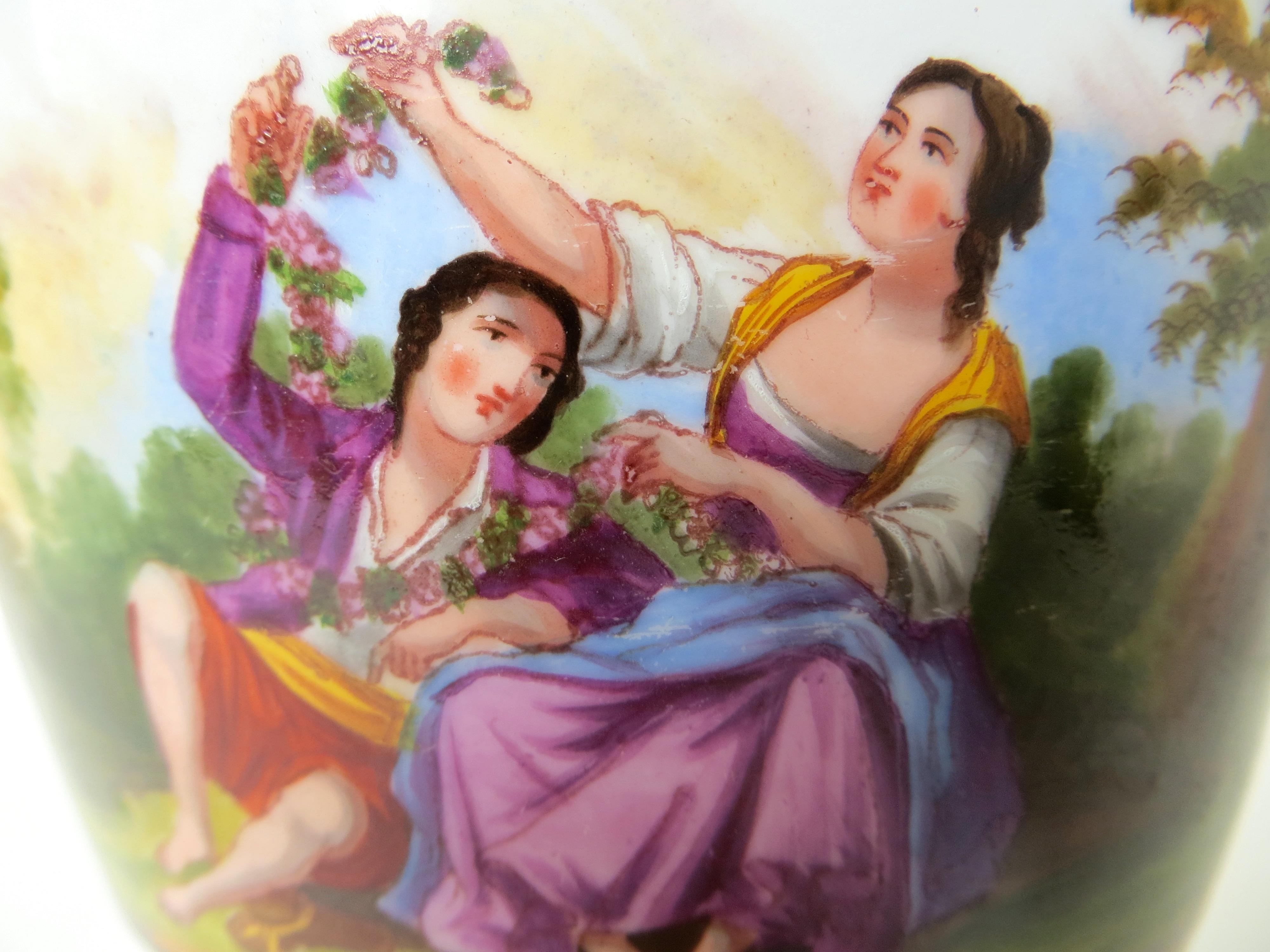 Macetero o maceta de loza inglesa de gran calidad de finales del siglo XVIII, con pequeño soporte de porcelana que lo acompaña. La imagen, pintada a mano, representa a una joven pareja elegantemente vestida con colores vivos, sentada bajo un árbol