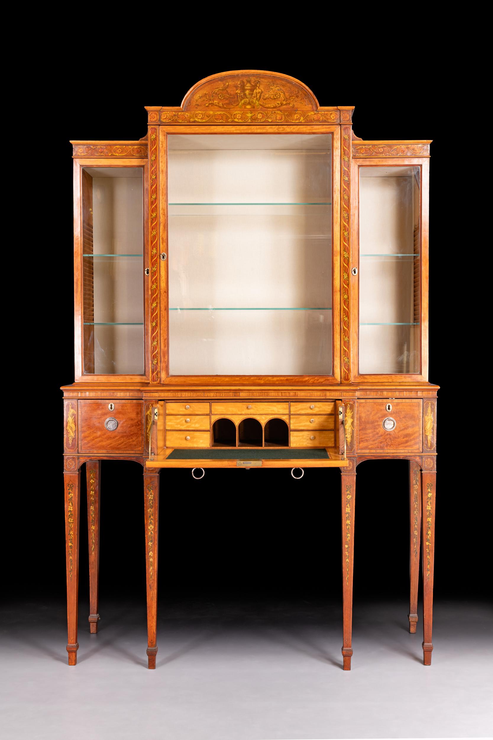 Un'elegante vetrinetta secretaire georgiana della fine del XVIII secolo in legno di raso e intarsio, di qualità eccezionale e di proporzioni eleganti. La parte superiore presenta un frontone centrale ad arco intarsiato con motivi neoclassici, tra