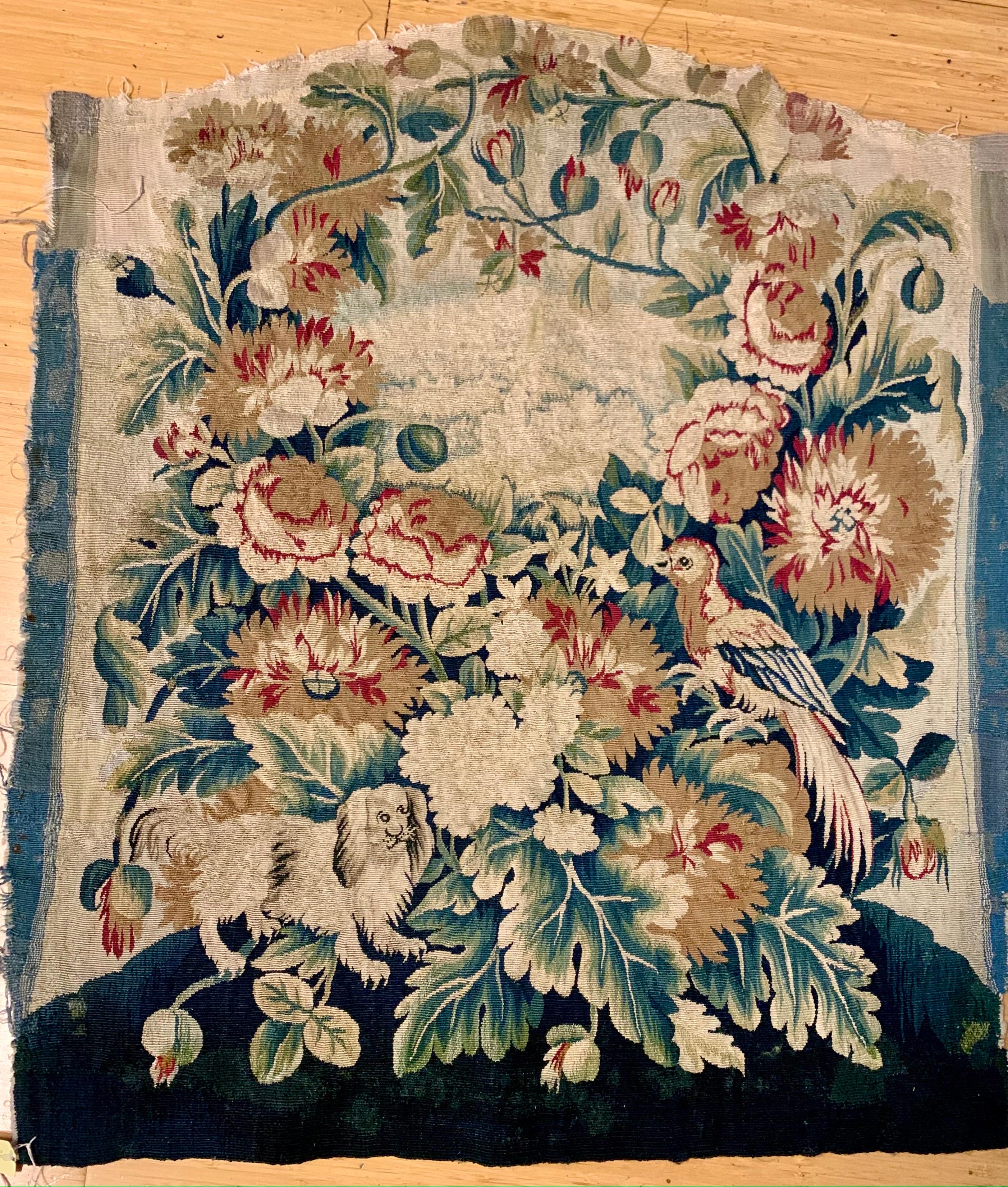 This is a silk and wool chair back cover fragment from antique 18th Century French Aubusson chair.  Chair back woven in wools and silks, each with floral wreath embroidery of peonies, poppies, and other. The wreaths surrounding a central landscape. 
