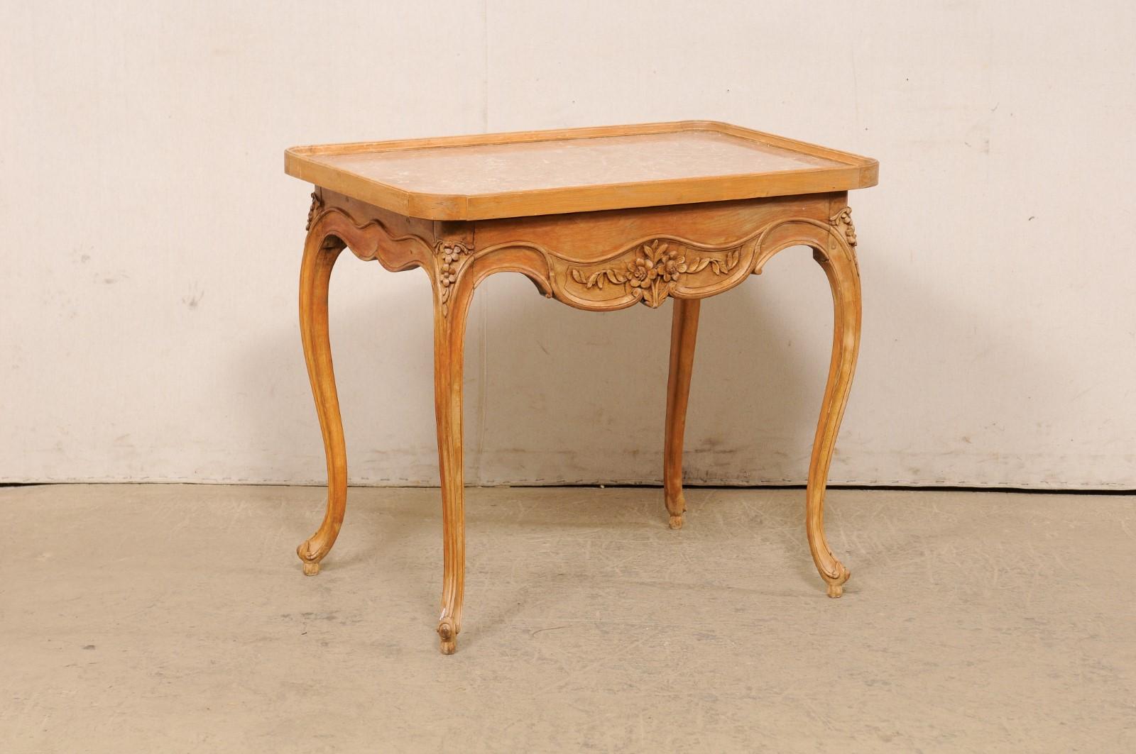 A French carved-wood occasional table with single drawer, from the turn of the 18th and 19th century. This antique side table from France has a rectangular-shaped, tray-style top with raised lip, rounded corners and fitted with marble at its center.