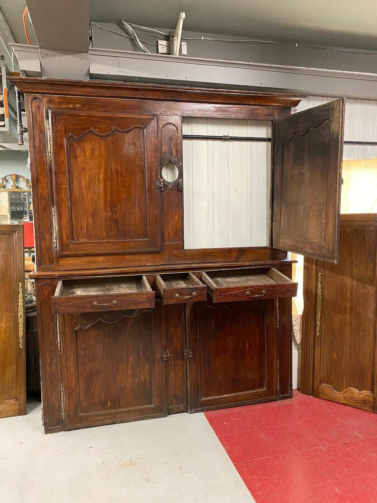 The antique Provincial Louis XV period boiserie en chen paneled wall paneling is from a French country chateau. The unit consists of a pair of large doors above 3 drawers, an opening for a fireplace or stove, and 2 doors below. The drawers are