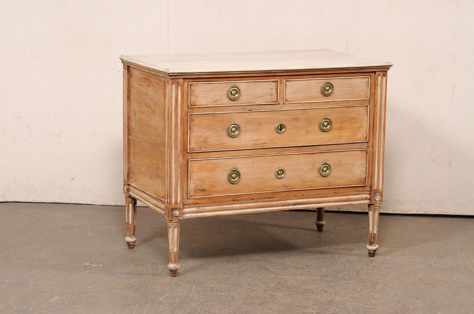 Cassettone italiano a quattro cassetti in legno intagliato e sbiancato/dipinto, a cavallo tra il XIX e il XIX secolo. Questa cassettiera antica proveniente dall'Italia presenta un piano di forma rettangolare, sopra una cassa ben decorata che ospita