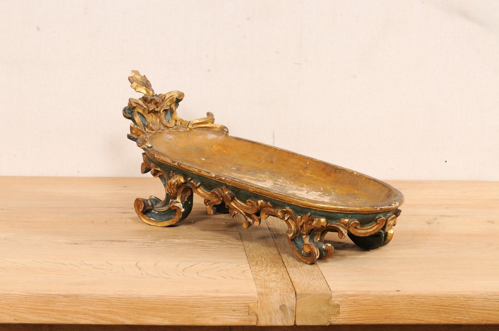An Italian carved and painted wooden bowl for display, from the turn of the 18th and 19th century. This antique bowl from Italy is oblong in shape, with front end/head tilted upward. The body is embellished with carved acanthus leaves and c-scrolls,