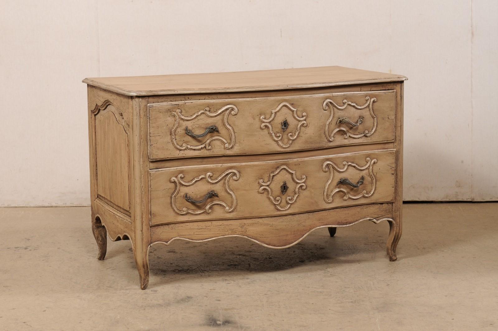 An Italian carved-wood two-drawer chest from the turn of the 18th and 19th century. This antique chest from Italy has been designed with a softly curved, serpentine-shaped body, with skirt carved on three sides, and raised on four petitely-carved
